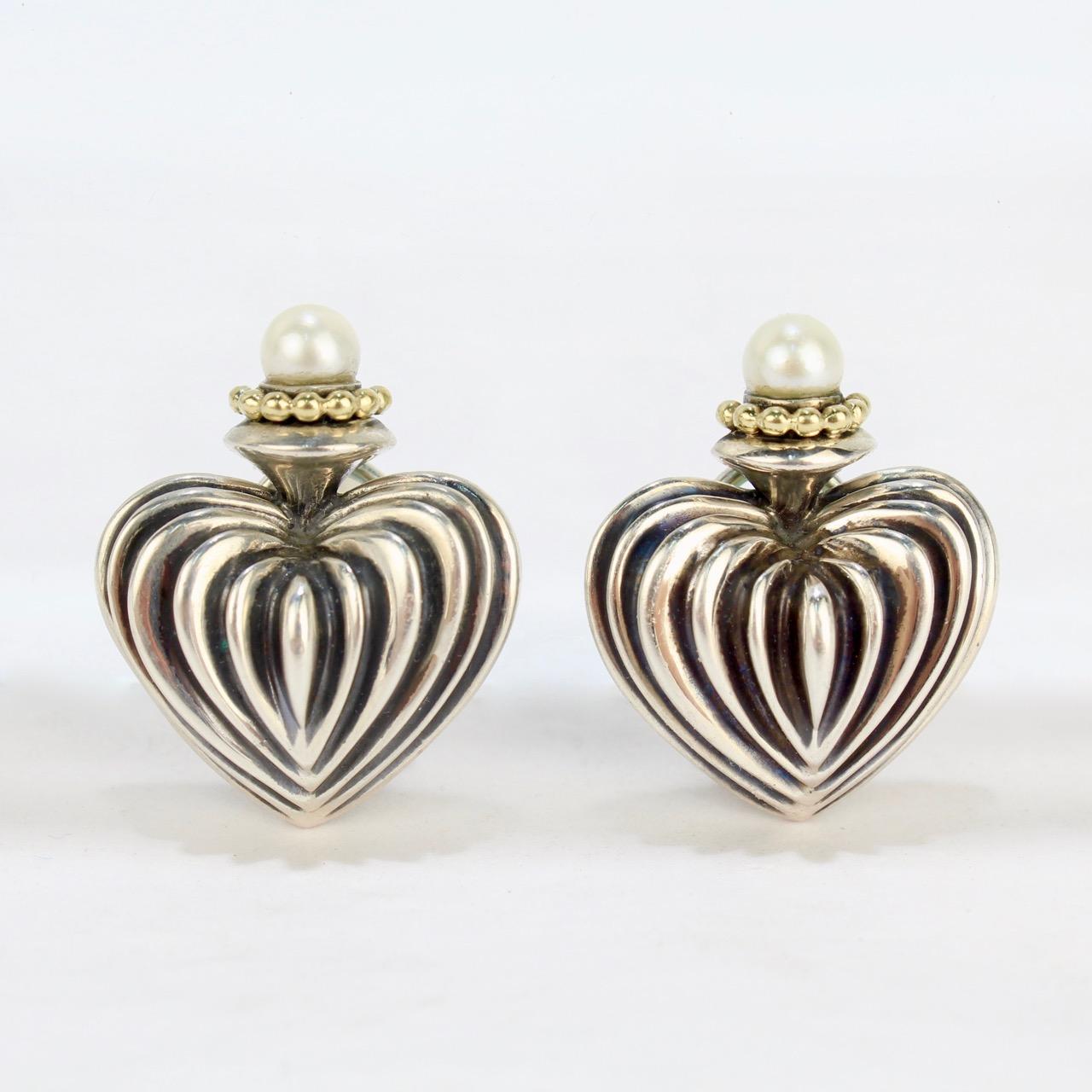 A fine pair of Lagos Caviar fluted heart omega-clip earrings.

Designed by Stephen Lagos and constructed of sterling silver, 18k gold, and each mounted with a pearl.

Each with an omega-clip including an 18K post.

Stamped to the interior 925 & 750