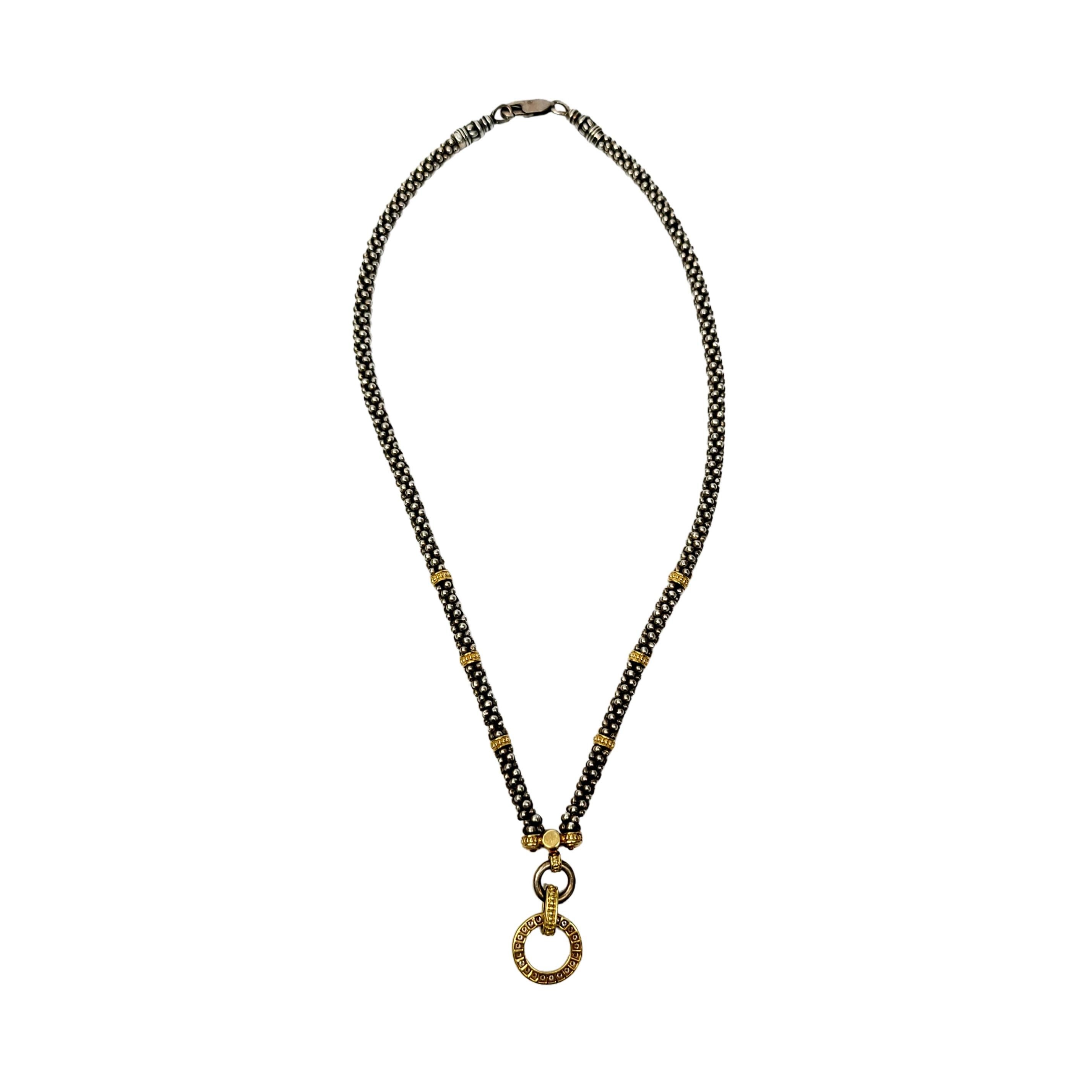 Sterling silver and 18K gold diamond Circle Game Caviar necklace by Lagos.

Sterling silver caviar necklace with 18K yellow gold stations meeting at a round diamond with a diamond circle pendant.

Measures approx 15  1/2