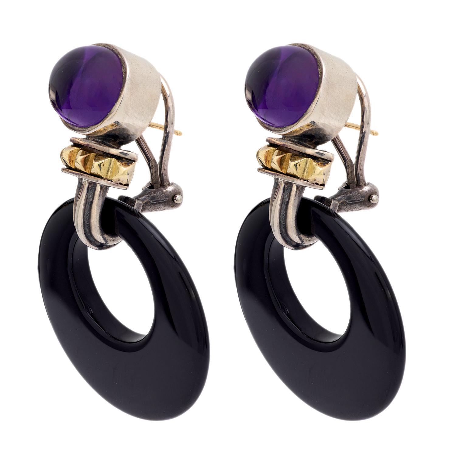 A stunning pair of Estate gemstone earrings by prestigious Philadelphia based designer Lagos! Crafted in 18k yellow gold and sterling silver, each earring begins with an amethyst surmount. The amethyst cabochons are held within smooth and simple