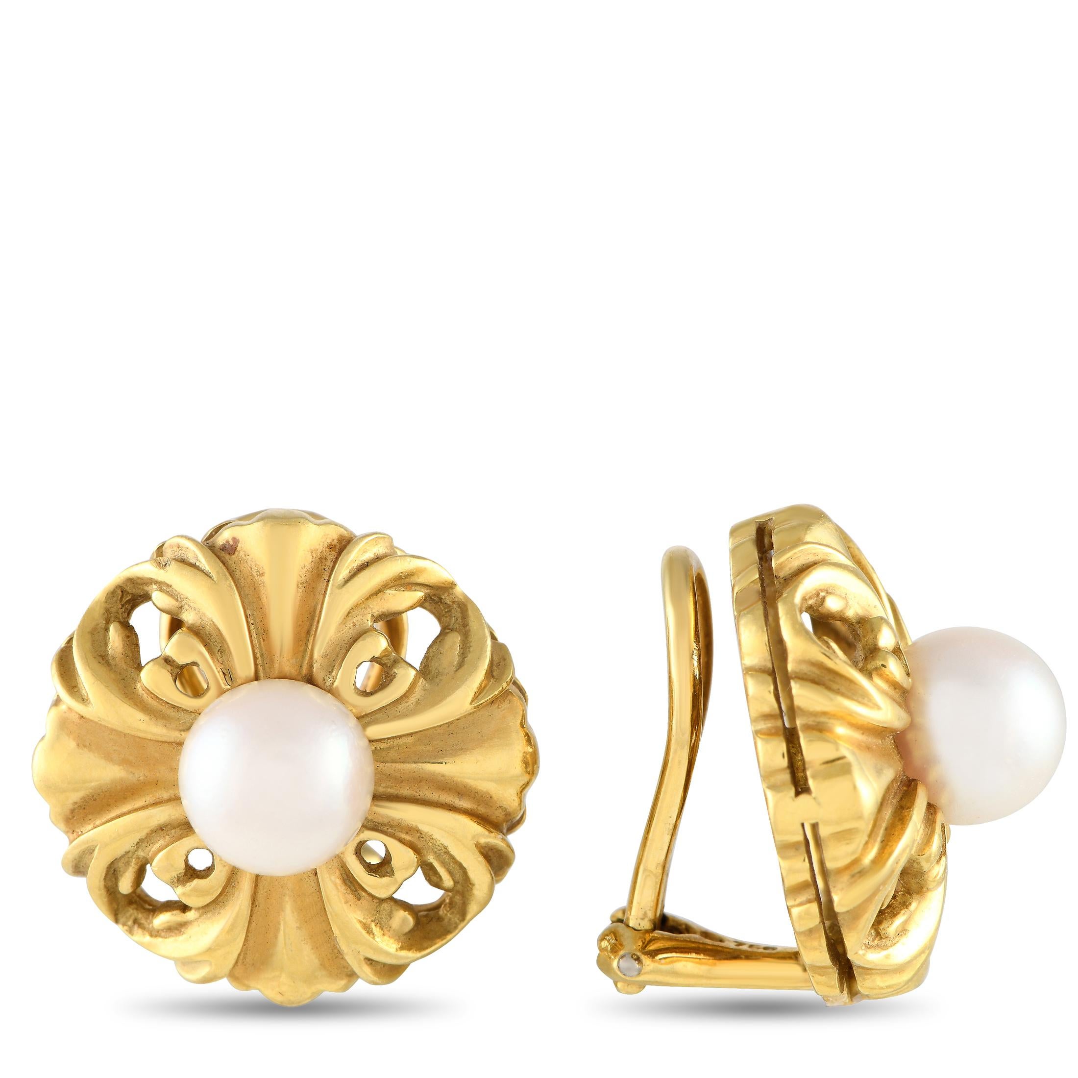 These vintage clip-on earrings can effortlessly charm their way through your wardrobe. Each earring features gracefully carved swirls and flourishes, inspired by the fleur-de-lys motif. At the center of each earring is a lustrous white pearl, giving