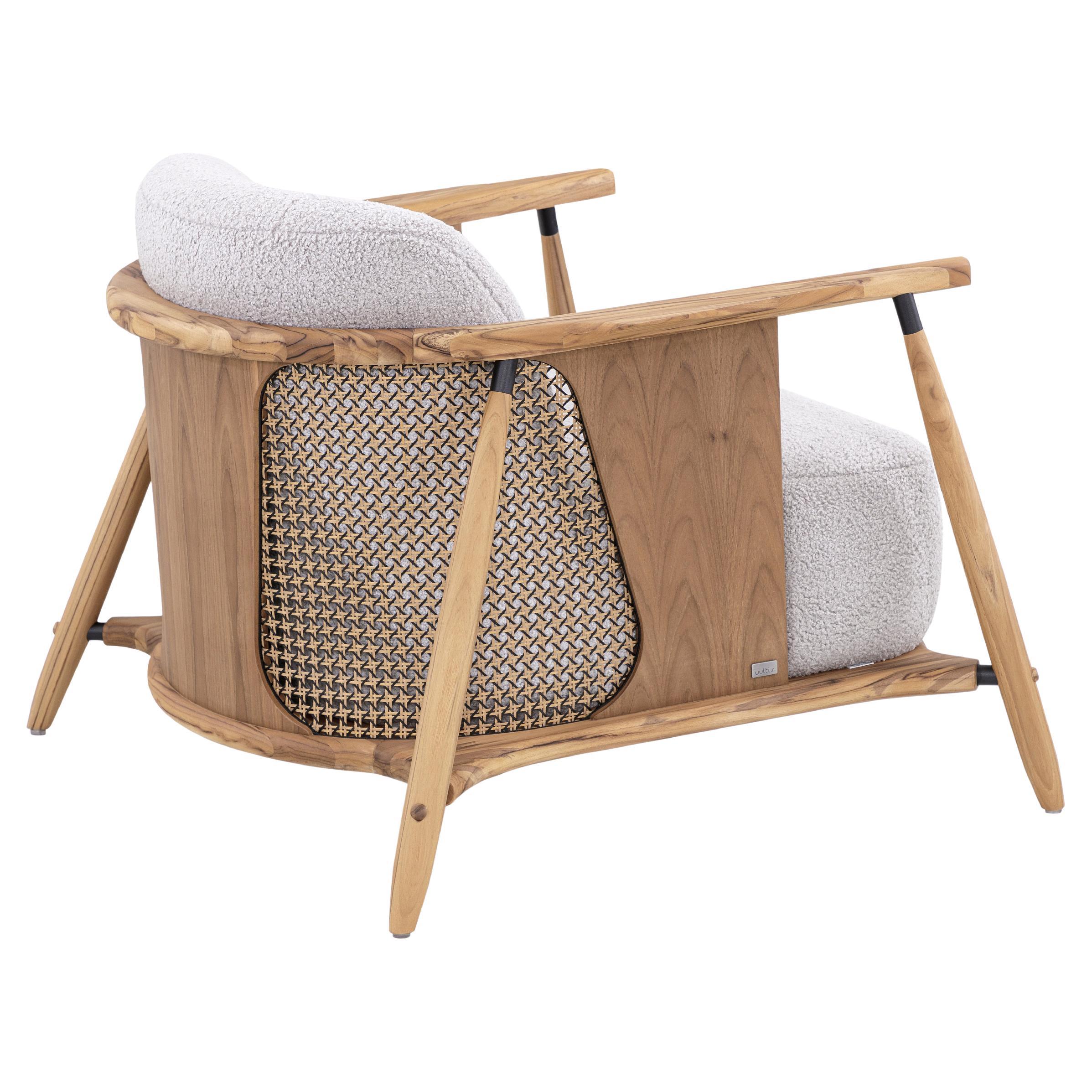 Una sedia occasionale in legno di teak Laguna, disegnata da Aciole Felix per Uultis, rivestita in tessuto grigio chiaro con accenti di canna nera e oro. La sedia occasionale Laguna è una miscela magistrale di eleganza naturale e design