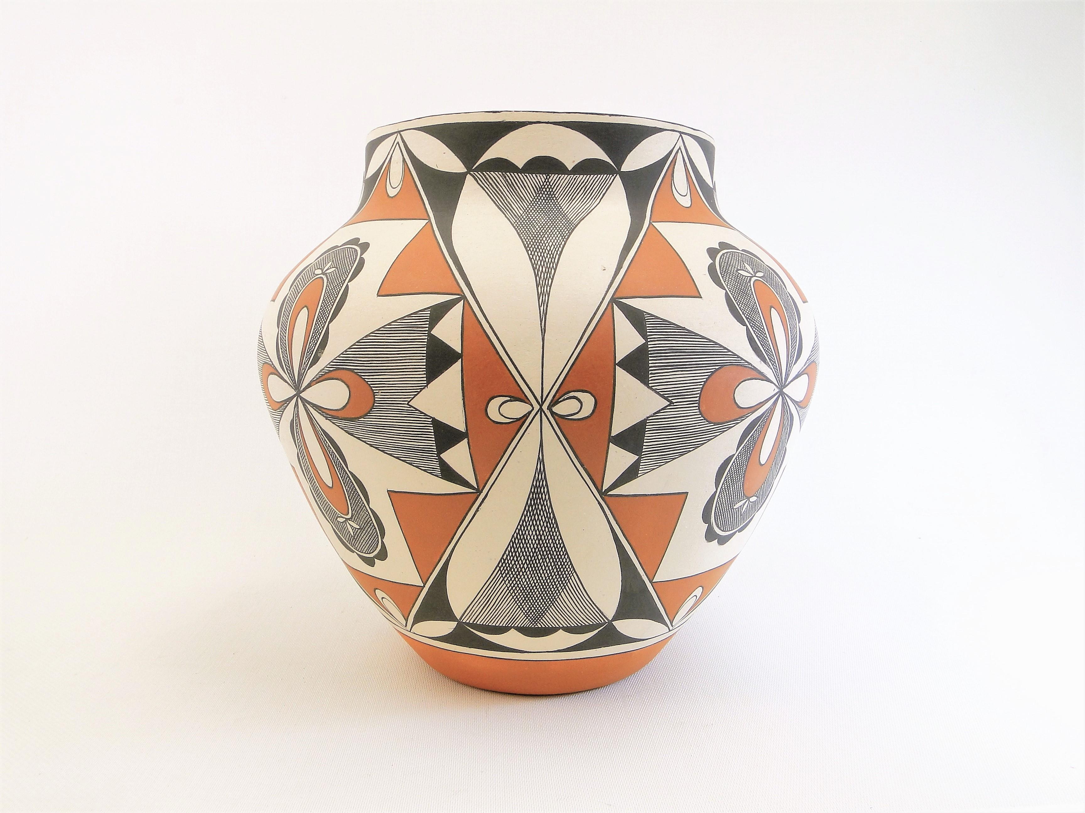 This is a beautiful example of hand coiled and hand painted Laguna Peublo pottery. The artist is Lee Ann Cheromiah. She is Laguna Peublo and was born in 1954. Lee Ann was taught how to make Laguna Pueblo Pottery by her mother, Evelyn Cheromiah.