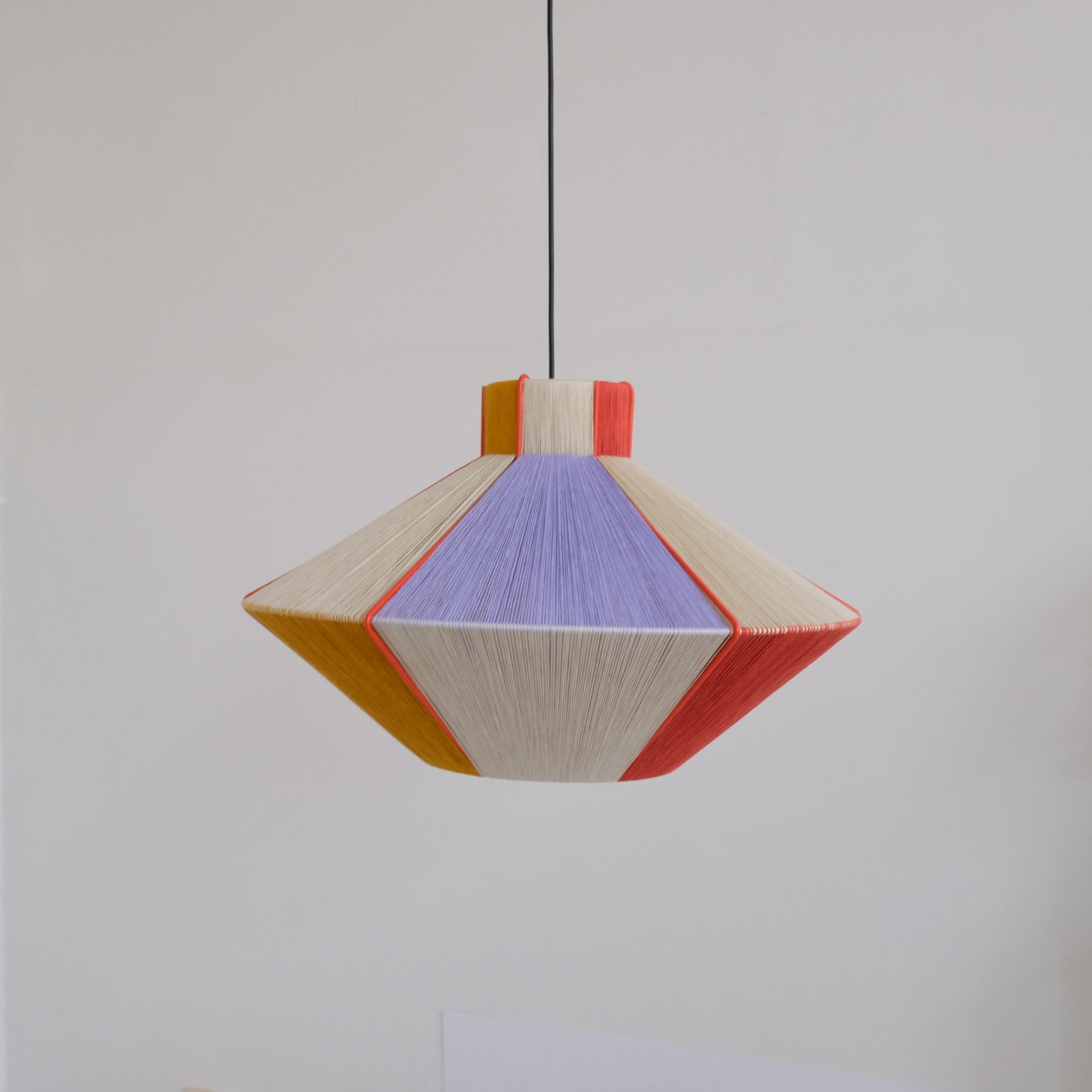 Each lamp is unique and completely handmade.

Their painted structural frames are produced by a local metal workshop, and Heymann hand-weaves these in her studio with Italian cotton thread.
She makes lamps in a variety of styles and sizes,