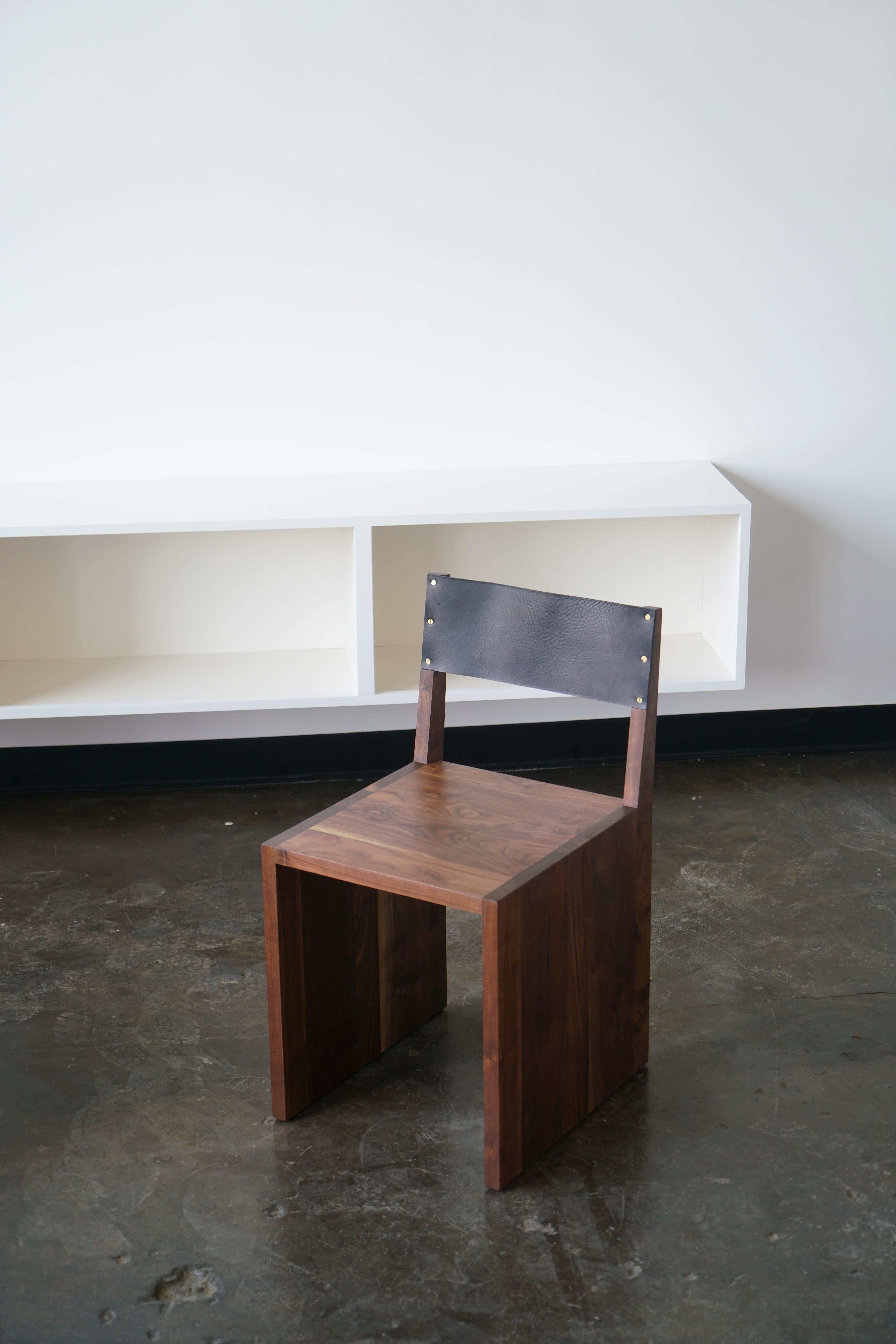 Ein minimalistischer Ess- oder Beistellstuhl aus dem Last Workshop.
Massives Nussbaumholz, schwarzes Leder, Messingschrauben.
Abmessungen: 18 