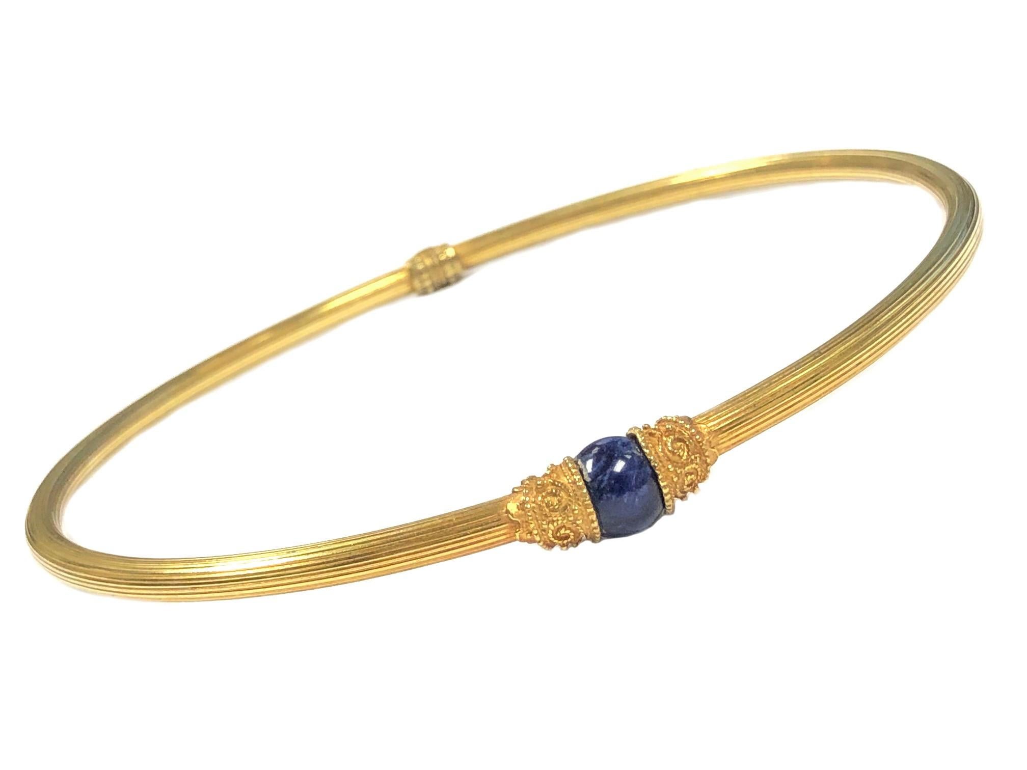 Circa 2000 Ilias Lalaounis Greece 18K Yellow Gold Collar Necklace. Having a light ribbed design and measuring 4.5 MM thick  (3/16 inch)  also having fine granulation gold work on the hinge and on either side of the 10MM Lapis Lazuli Round bead.
