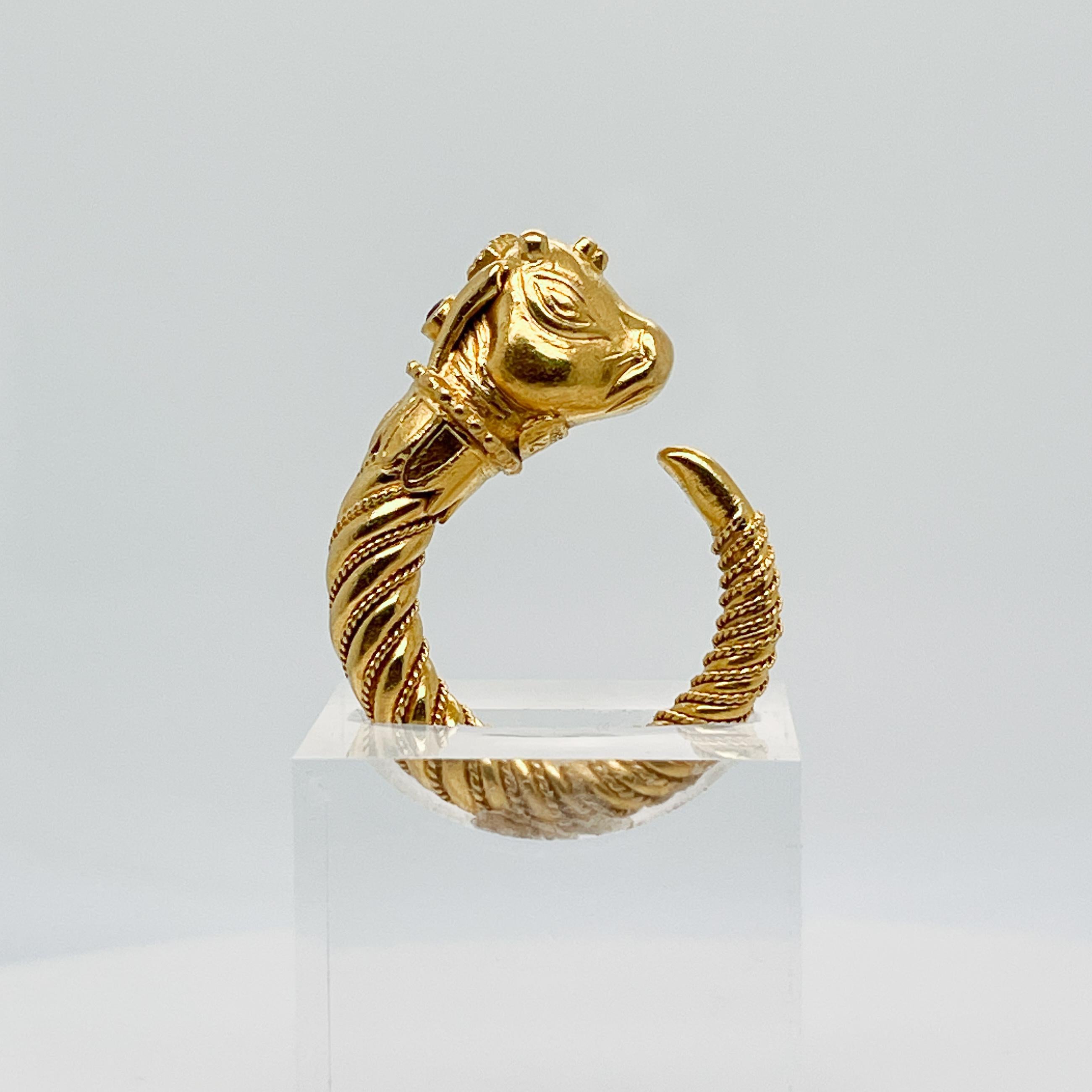 A fine Greek Revival style ring.

In 18 karat yellow gold and set with a small round amethyst.

In the form of a stylized bull's head with granulation mounted on a tapered and twisted horn shaped band.

 By Lalaounis.

Simply a wonderful ring from