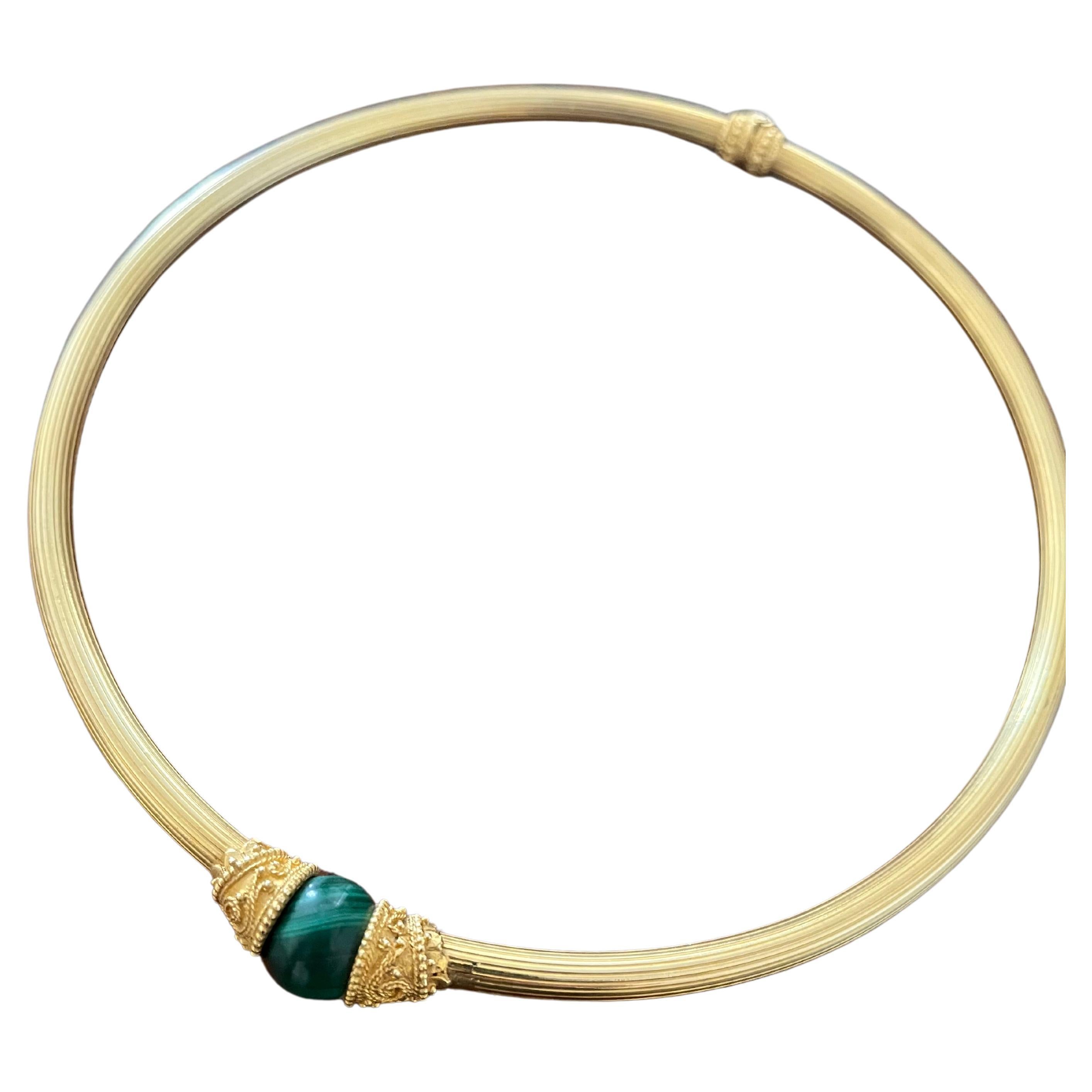 lias Lalaounis 18 Karat Gold Malachite Choker Necklace. This unique 8mm wide hinged choker features a single malachite bead set in one of the ends. Both ends of this choker and near the hinge contain gold bead, rope, and scroll designs. Stamped near