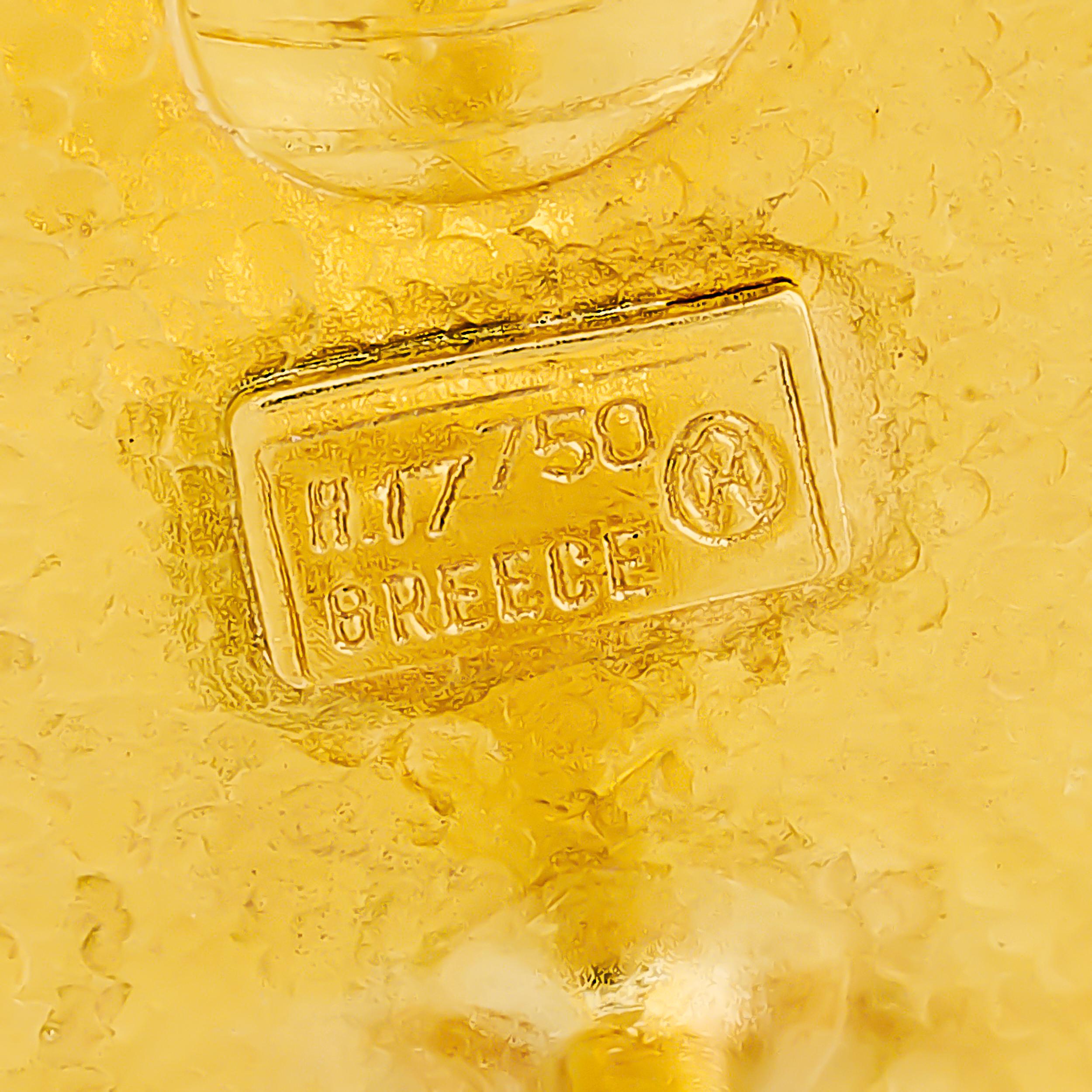 Questi orecchini Lalaounis in oro giallo 18 carati sono progettati come eleganti perni circolari, con una cupola centrale martellata circondata da un bordo granulato.

Realizzato in oro 18 carati.
Il bracciale reca il timbro: 