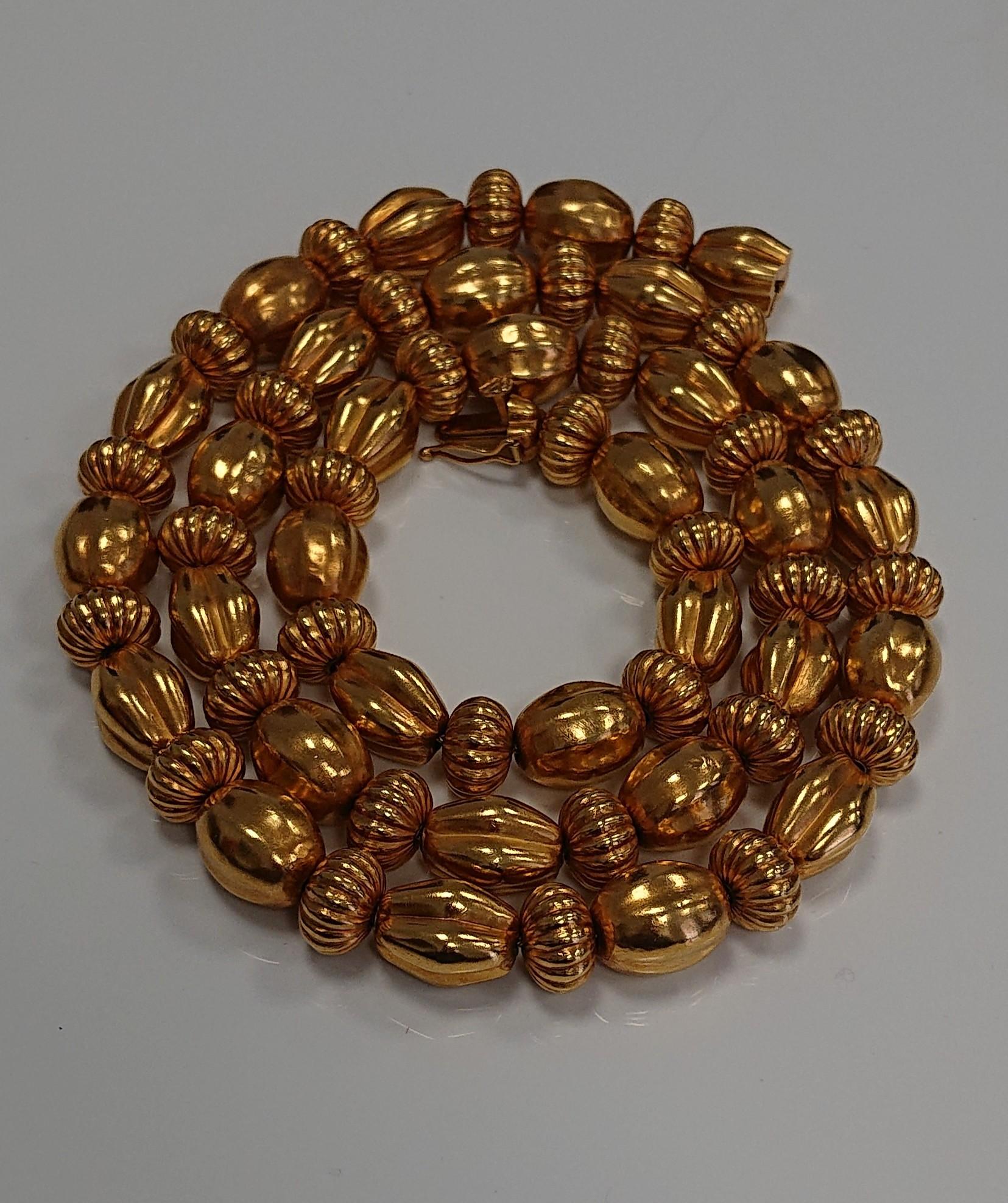 A Lalaounis 22 Carat Yellow Gold Minoan Fluted Bead Necklace. Circa 1970s. The alternating fluted gold beads with 22ct hand-woven chain. Stamped 
