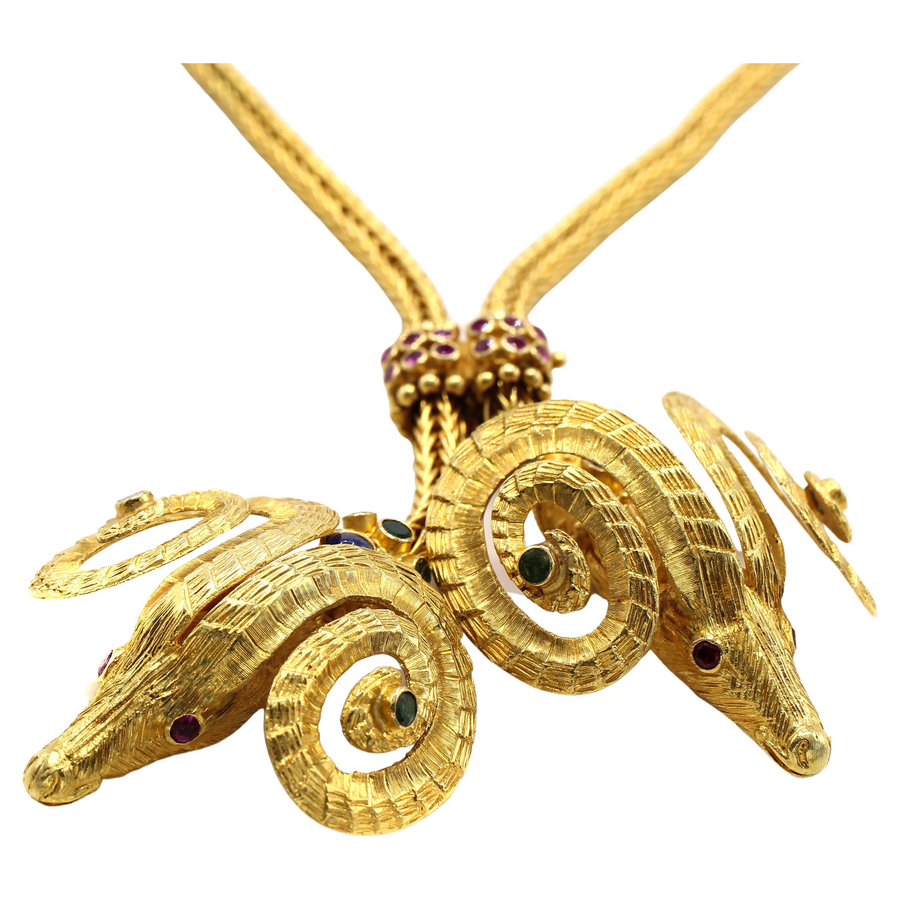 Dieses schicke und äußerst tragbare Collier wurde von dem berühmten griechischen Juwelier Ilias Lalaounis entworfen und in Handarbeit gefertigt. Es besteht aus 2 Widderköpfen, die mit Rubinen, Smaragden und Saphiren besetzt sind und aus fein