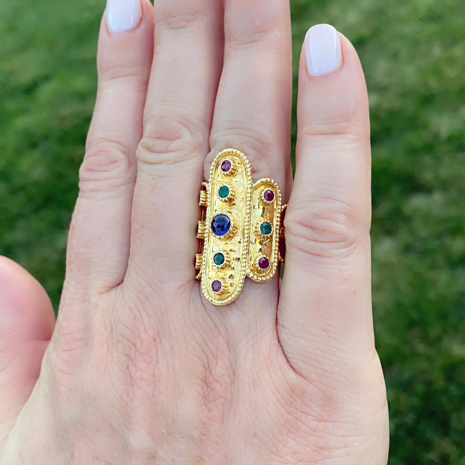 By Lalaounis, one of the most renowned Greek jewelry designers, this 18k gold ring makes a statement that can be worn every day. Designed with tapering cobblestone cartouches, each is bezel-set with a cabochon sapphire, with round-cut rubies and