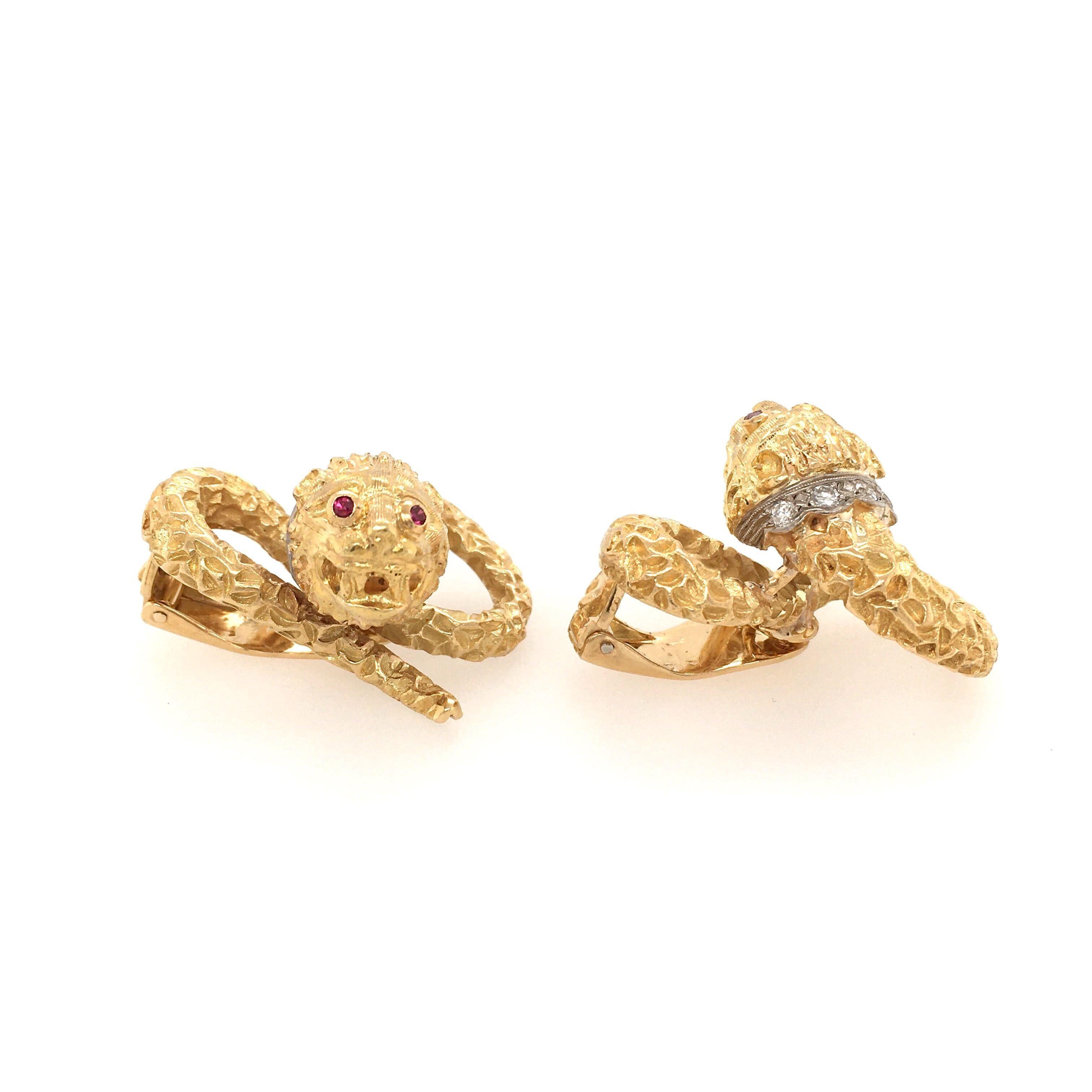 A pair of 18 karat yellow gold, diamond and ruby chimera earrings. Lalaounis. Of textured winding design, enhanced by a pave set diamond collar and circular cut ruby eyes. Length is approximately 1 1/4 inches, gross weight is approximately 29.2
