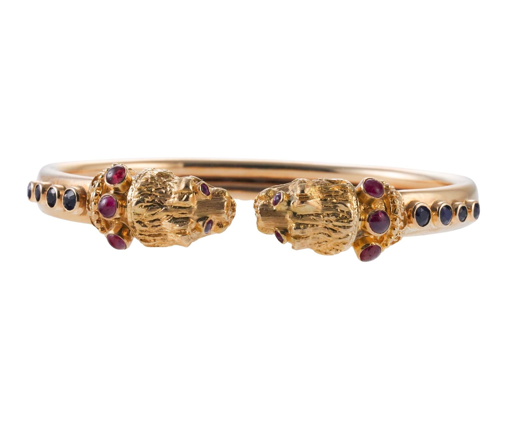 Lalaounis Greece, 18k gold Chimera Bangla bracelet, set withcabochon rubies and sapphire eyes. Bracelet will fit an approx. 7