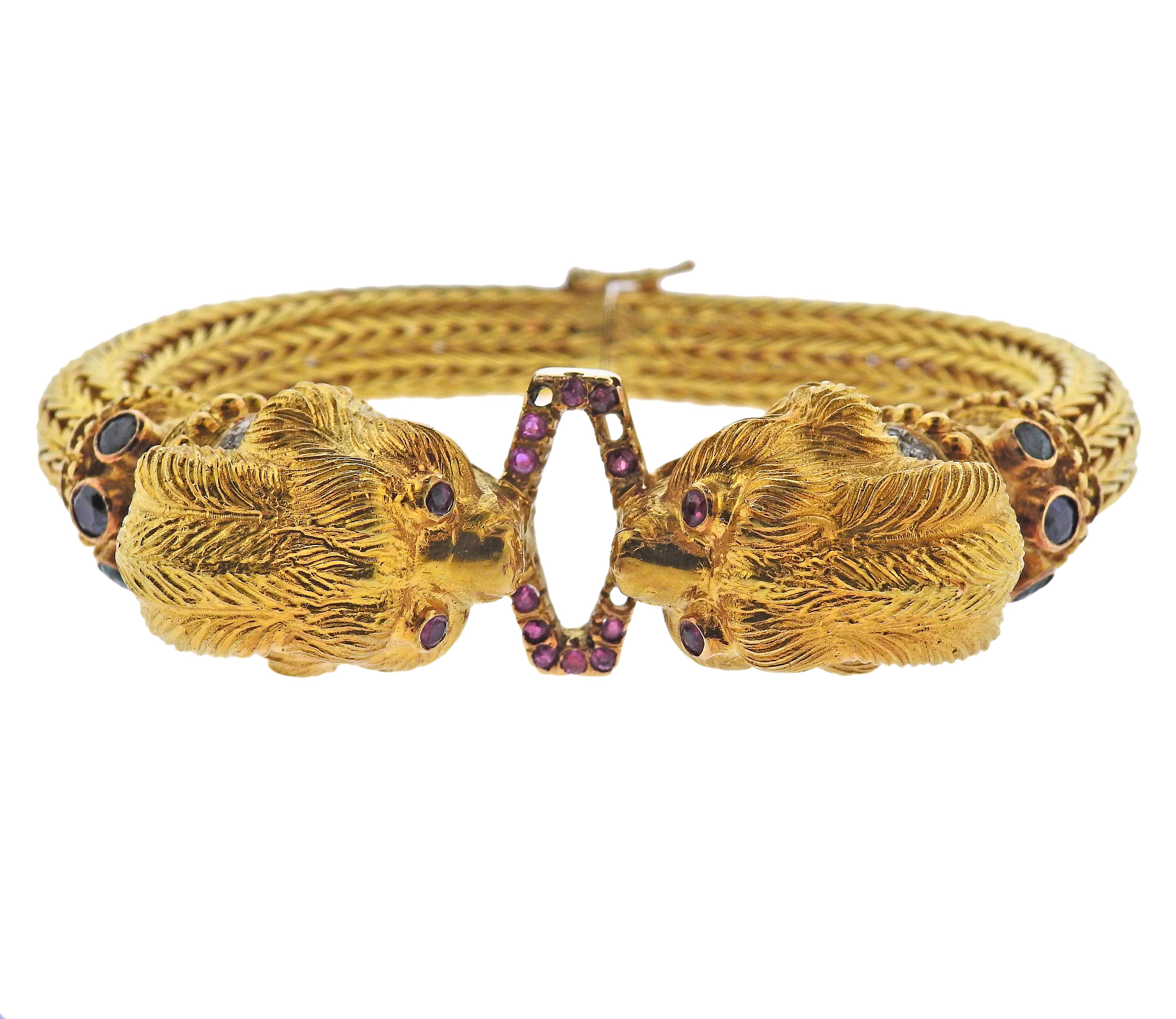 18k yellow gold bracelet by Greek designer Ilias Lalaounis, featuring two large Chimera heads, adorned with rubies, sapphires and diamonds (few stones are missing). Bracelet is approx. 7