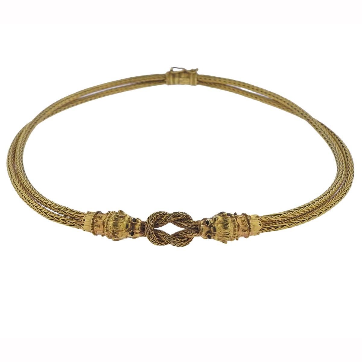 18k yellow gold necklace, featuring two chimera heads, interlocked with a Hercules knot. Decorated with ruby eyes, designed by Greek jewelry maker Ilias Lalaounis. Necklace is 15.75