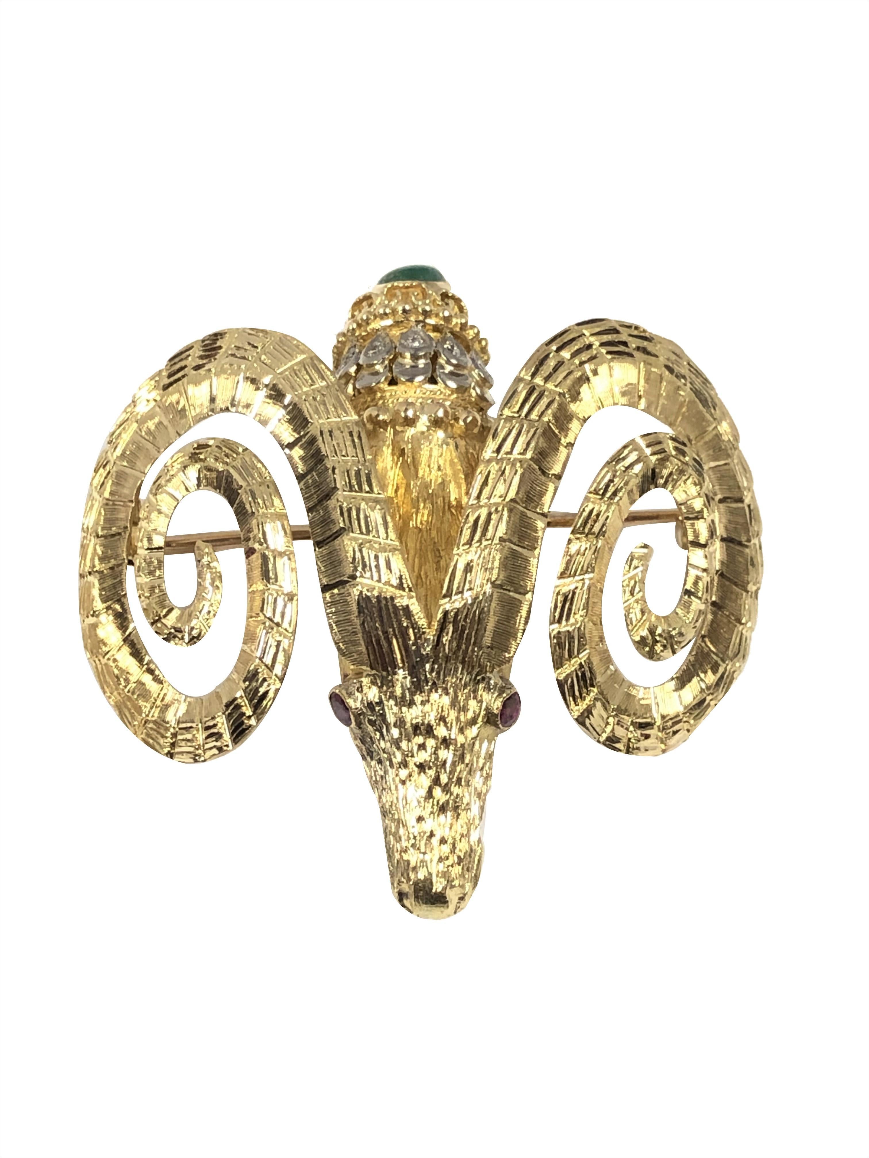 Circa 1980 Ilias Lalaounis Rams Head Brooch, measuring 1 7/8 X 1 7/8 inches and weighing 30.4 Grams, finely detailed with Gold chasing and texturing a famous Lalaounis trademark and set with Diamonds, a Cabochon Emerald and Ruby Eyes. 