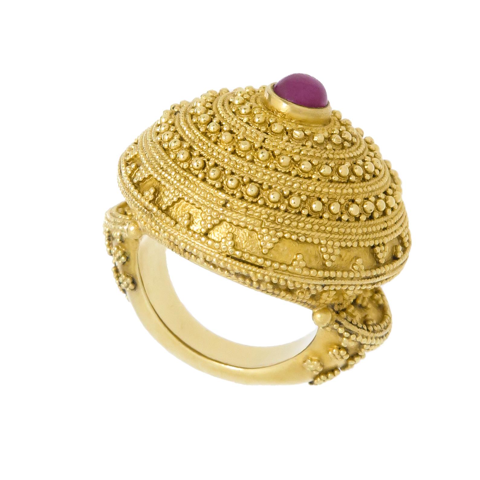 Circa 2000 Illias Lalaounis 18K Yellow Gold Dome Ring, the ring top measures 1 1/4 inches in diameter and 1/2 inch in height. Very fine Gold Granulation work and centrally set with a Cabochon Ruby of approximately 1/2 carat. Finger size 4. Excellent