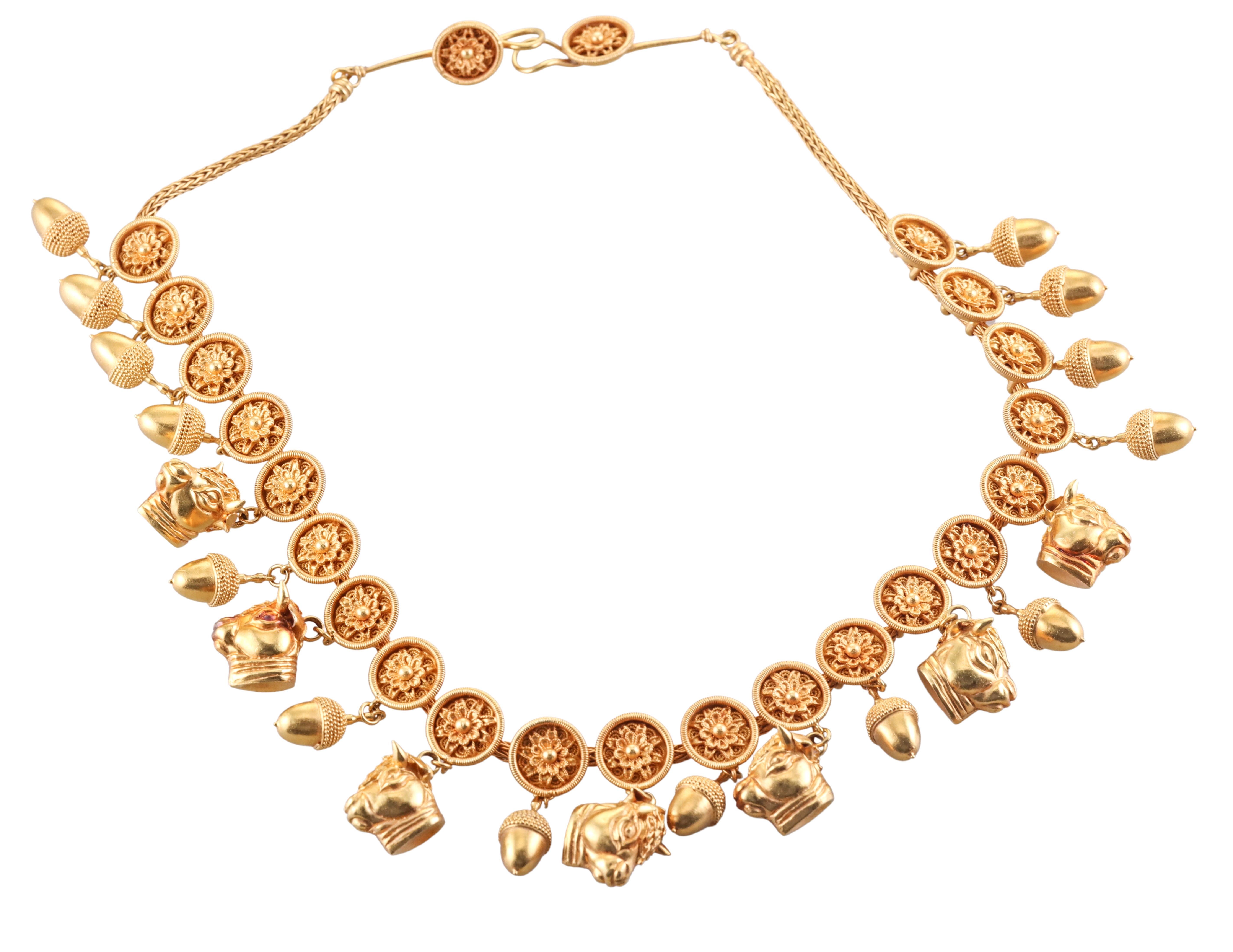 Iconica collana in oro giallo 22k di Ilias Lalaounis, uno degli stilisti greci più in vista del momento. La collana è caratterizzata da 21 elementi con un fiore e una ghianda penzolante o una testa di toro. La collana è lunga 15,5