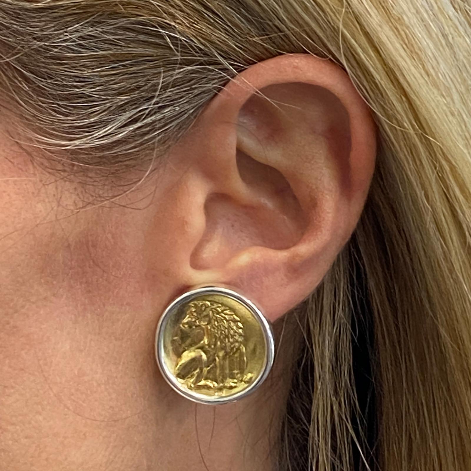 Designer earrings by Ilias Lalaounis are fashioned in sterling silver. The coin shape earrings feature an embossed wolf on gold plated sterling silver centers. The earrings are clip backs, and signed Greece 925 A21 with Lalaounis hallmark. 