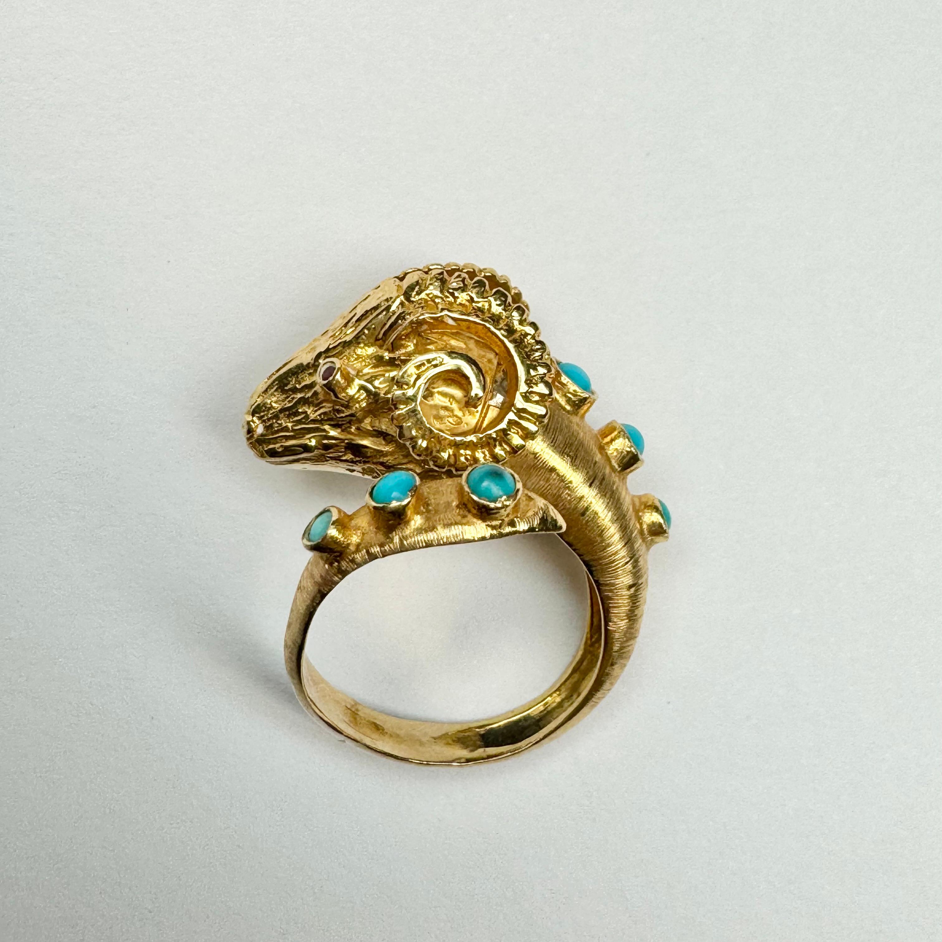 Incredibly unique vintage wrap ring in solid 18K gold. The ram's head is artistically crafted in solid yellow gold with glittering ruby eyes, bezel set. There are six beautiful cabochon turquoise running along the back and accenting the end of the
