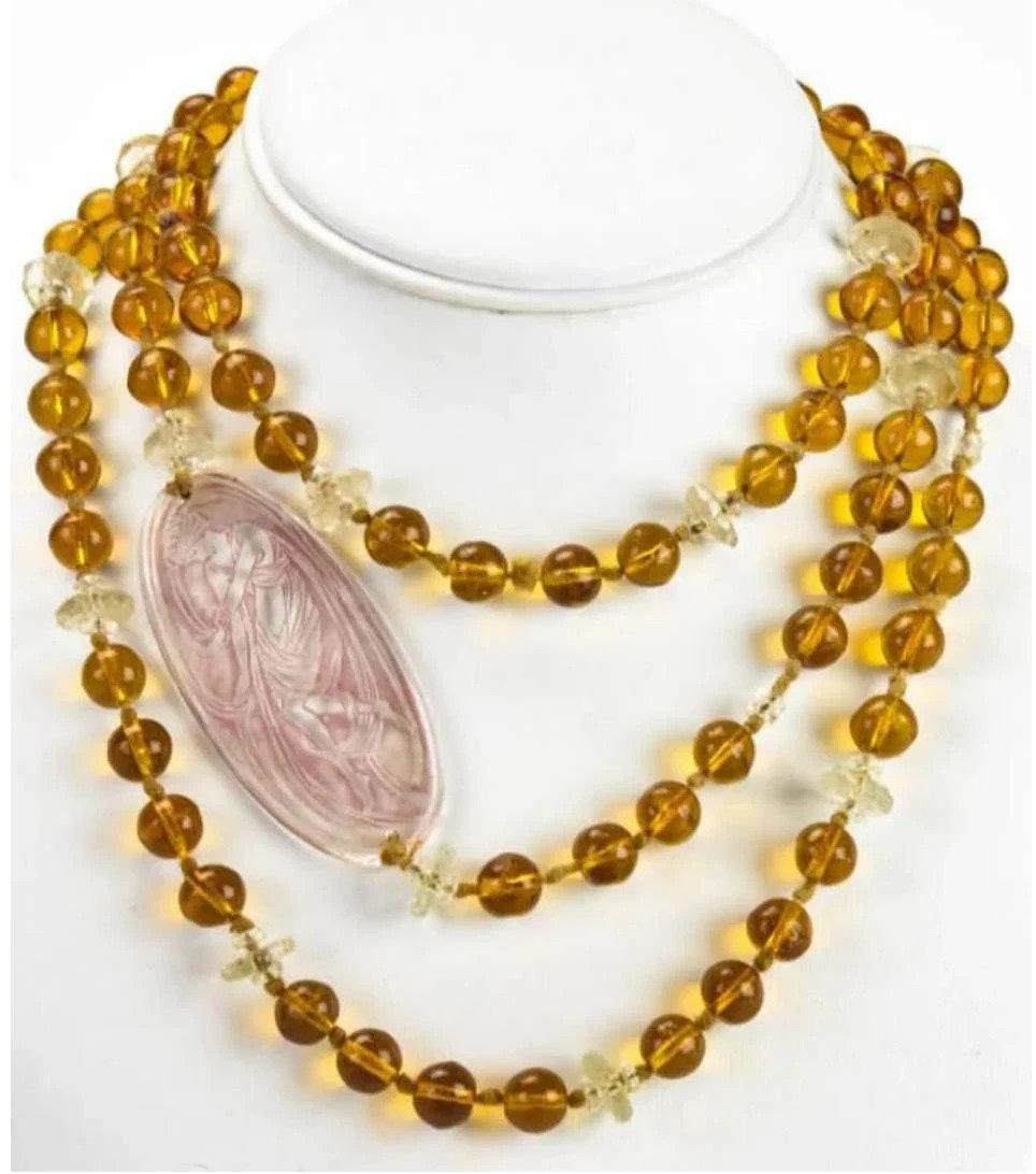 Rene Lalique art glass plaque on a necklace made of Lalique glass beads, circa 1927. Hand knotted necklace with amber glass beads, rock crystal spacers and an oval signed Lalique plaque. 

Measures 54 inches in length. Please disregard dimensions
