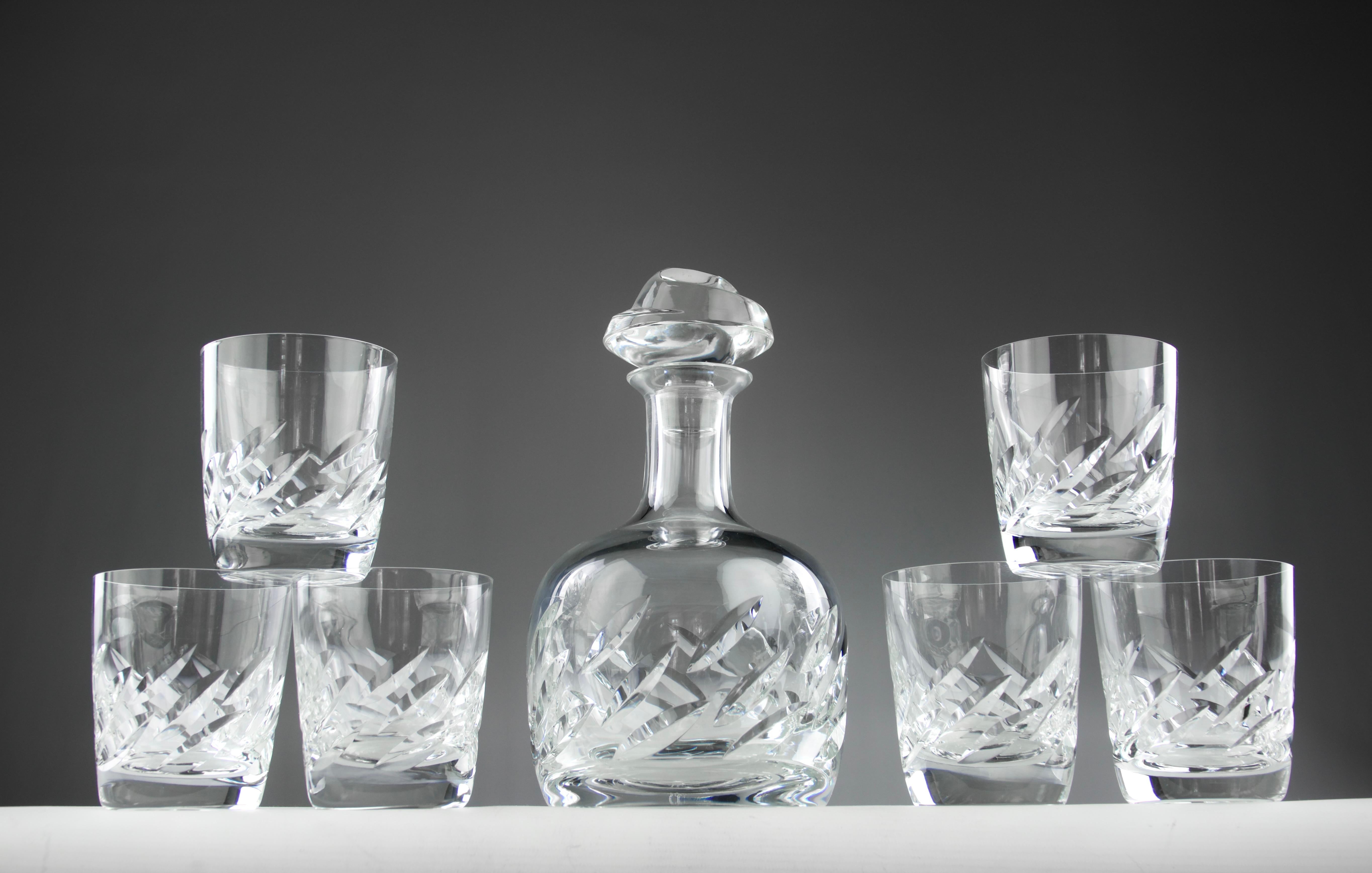 Superb Artois model liqueur set by the Lalique France manufacture. Two are available and each consists of six glasses and a decanter, all decorated with gouges carved in the crystal. Signed 