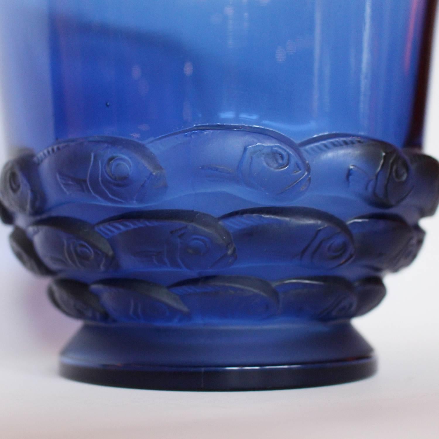 Monaco, an Art Deco glass vase. Blue clear and frosted press moulded glass, decorated in a band around the base with a stylised design of a school of fish. Model no. 1049. Literature: Marcilhac, R Lalique Catalogue Raisonné de L’Œuvre de Verre