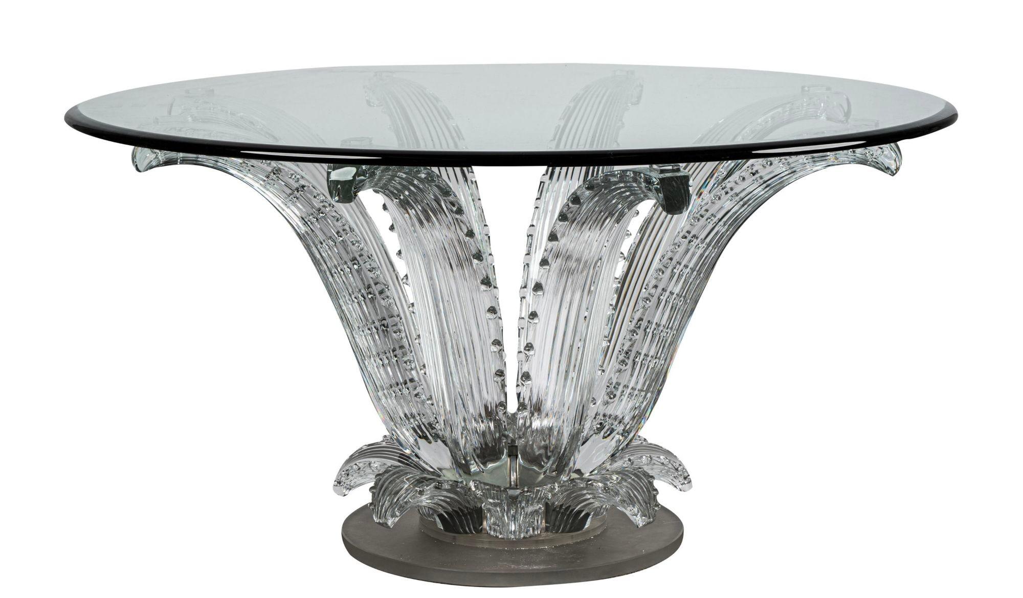 A majestic sculptural center table made by the renowned brand Lalique, France in the 1980's (created in 1951). It consists of a clear crystal base resembling cactus leaves and a round base. it also includes a chromed bronze frame atop a round glass