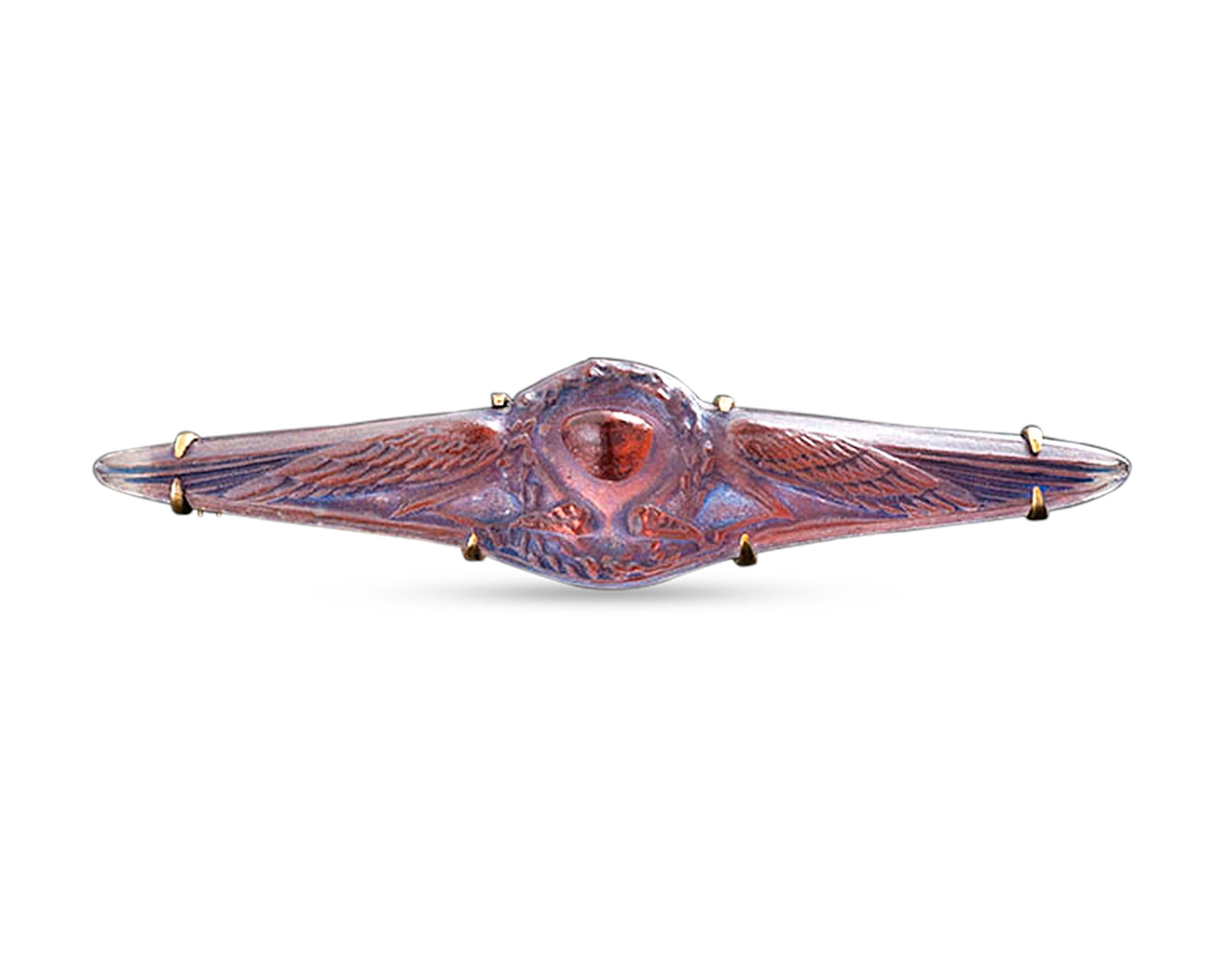 A quintessential jewel of Art Nouveau design, this carved glass brooch by the legendary René Lalique showcases all of the best qualities of this legendary jeweler. A high relief carving of wings surrounding the central pendant reveals the iridescent