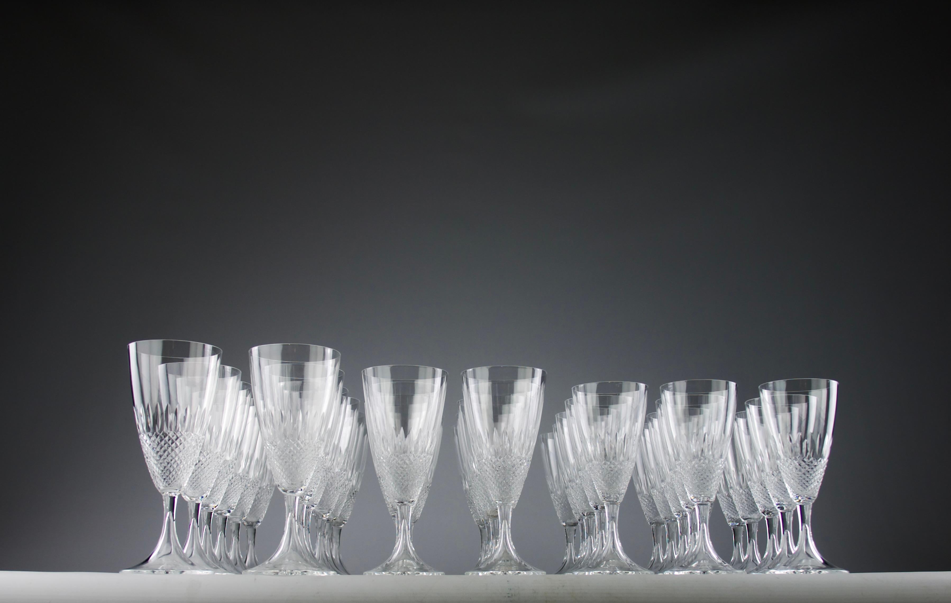 Precioso servicio de cristal modelo Chinon de Lalique de los años 70 compuesto por 39 piezas con 12 vasos altos, 10 vasos medianos y 17 vasos más pequeños. Todas tienen forma de flauta con un velo de puntas de diamante que cubre la mitad inferior