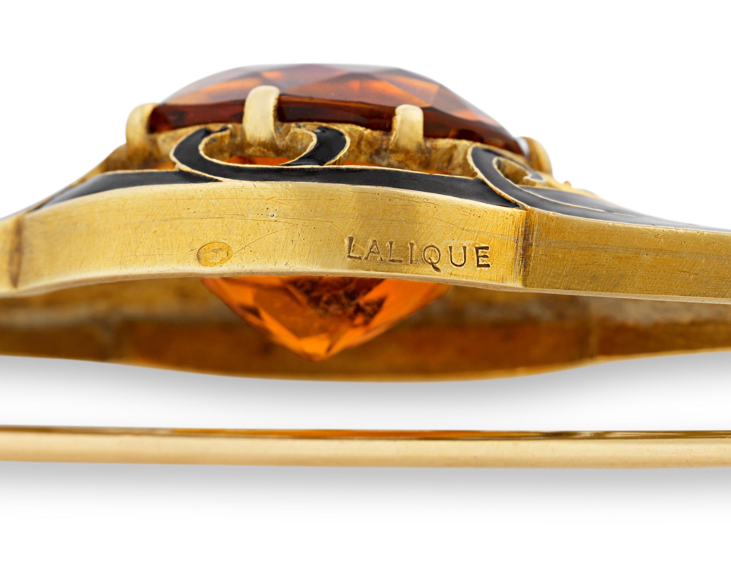 A quintessential example of Art Nouveau jewelry design, this stunning citrine and enamel brooch is the work of the legendary artisan René Lalique. Elegantly curved panels of black enamel and gold highlight the citrine's incredible vibrancy of color.
