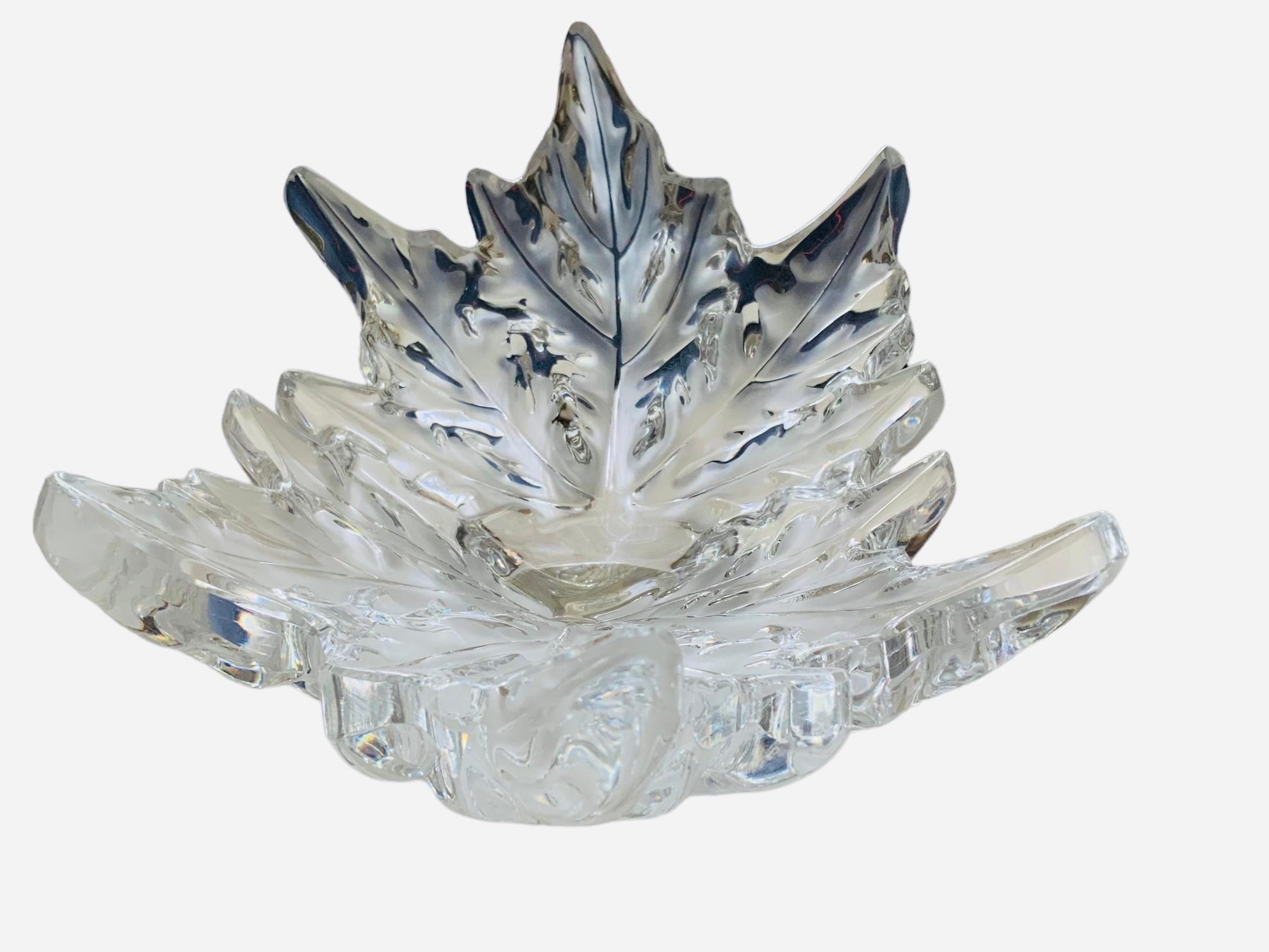 This is a Lalique Crystal Champs- Elysses medium size oval bowl vase. It depicts multiple horse chestnut leaves arranged around a circular center base. Below the base, it is the acid etched Lalique circle R, France hallmark.