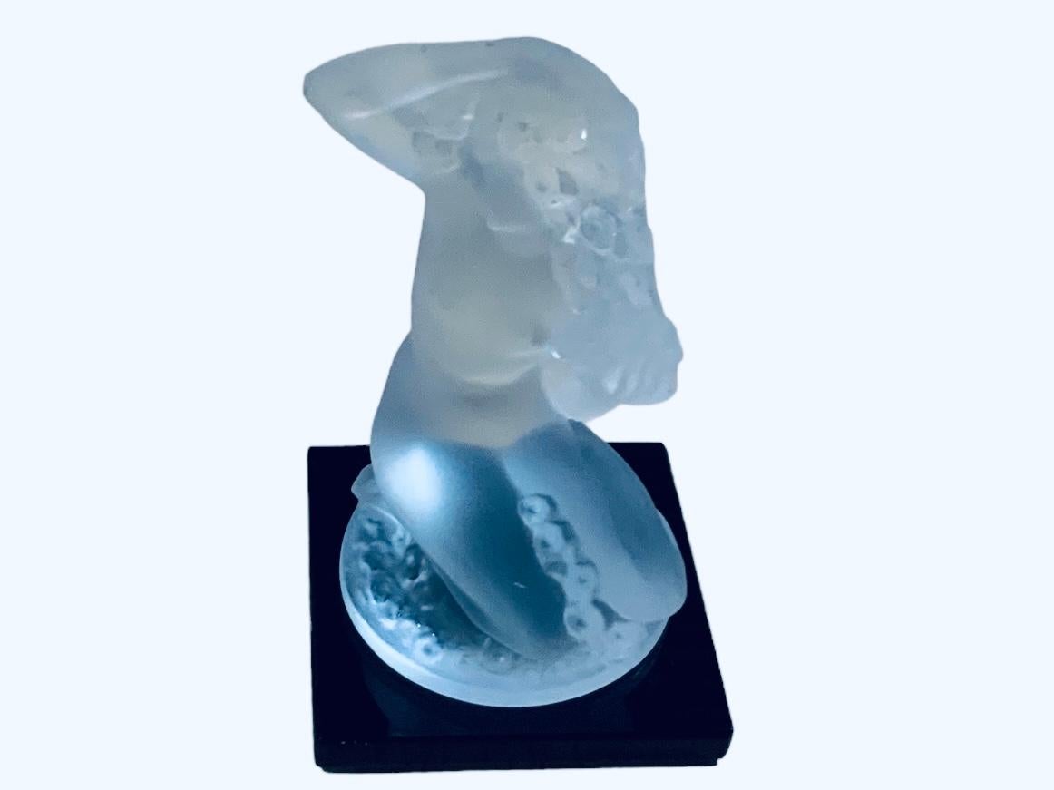 This is a Lalique Frosted Crystal Nude Lady in Bubble sculpture. It depicts a nude woman in a sensual kneeling position washing her hair and covered by some bubbles. The sculpture’s black crystal square shaped base is acid etched signed
