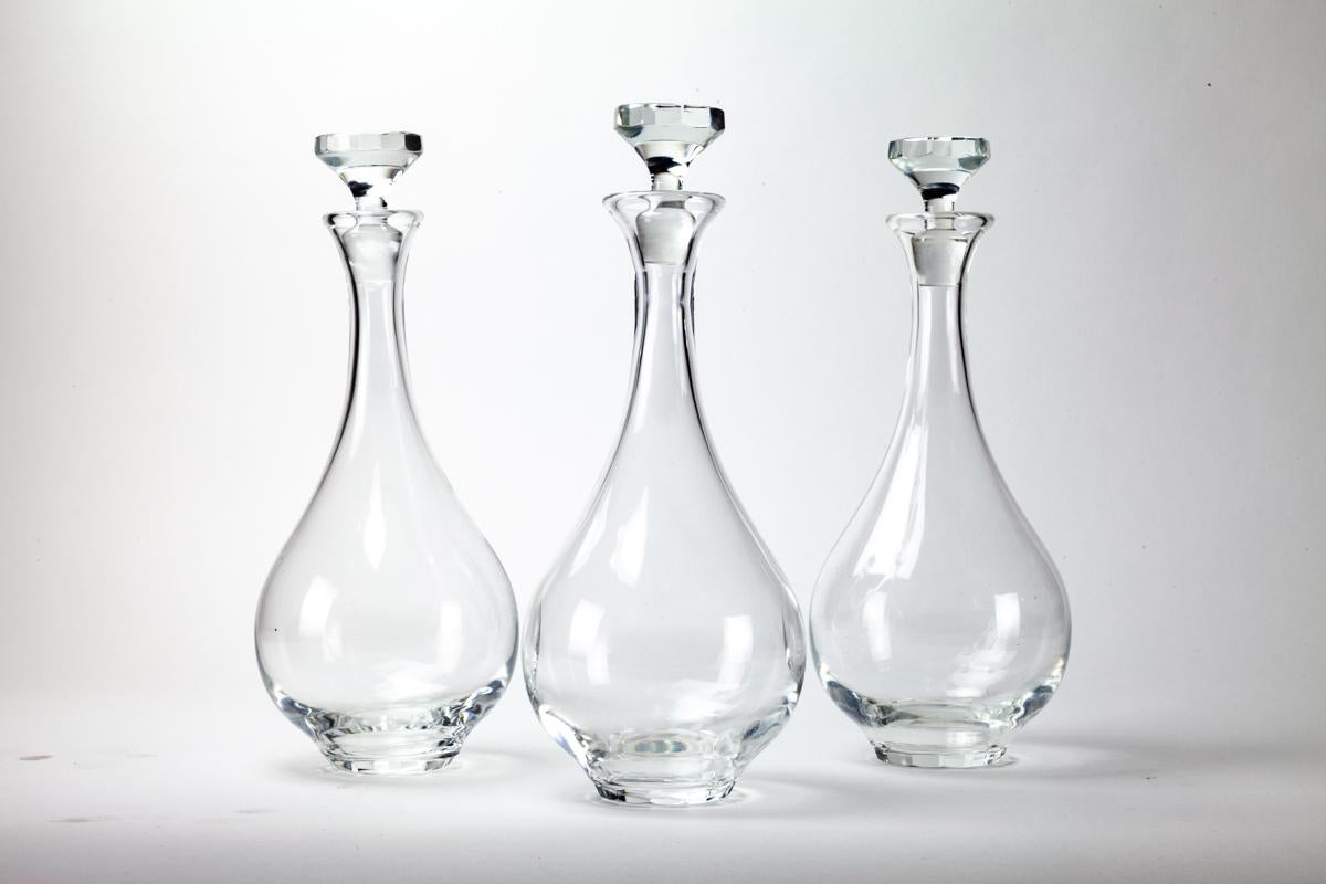 These crystal teardrop-shaped decanters are by the renowned crystal company, Lalique. They have been making France's finest crystal since the mid 1800's. 

There are 3 available, to be bought individually, or as a group. Each is in fantastic