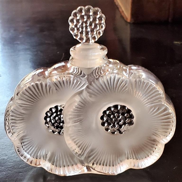 Presenting a beautiful Lalique double daisy perfume bottle.

Made by Lalique, France, circa 1960.

This is a Classic Lalique piece with opalescent glass with embellished daisy flowers and central stamen. Matching stamen shaped stopper.

Fully
