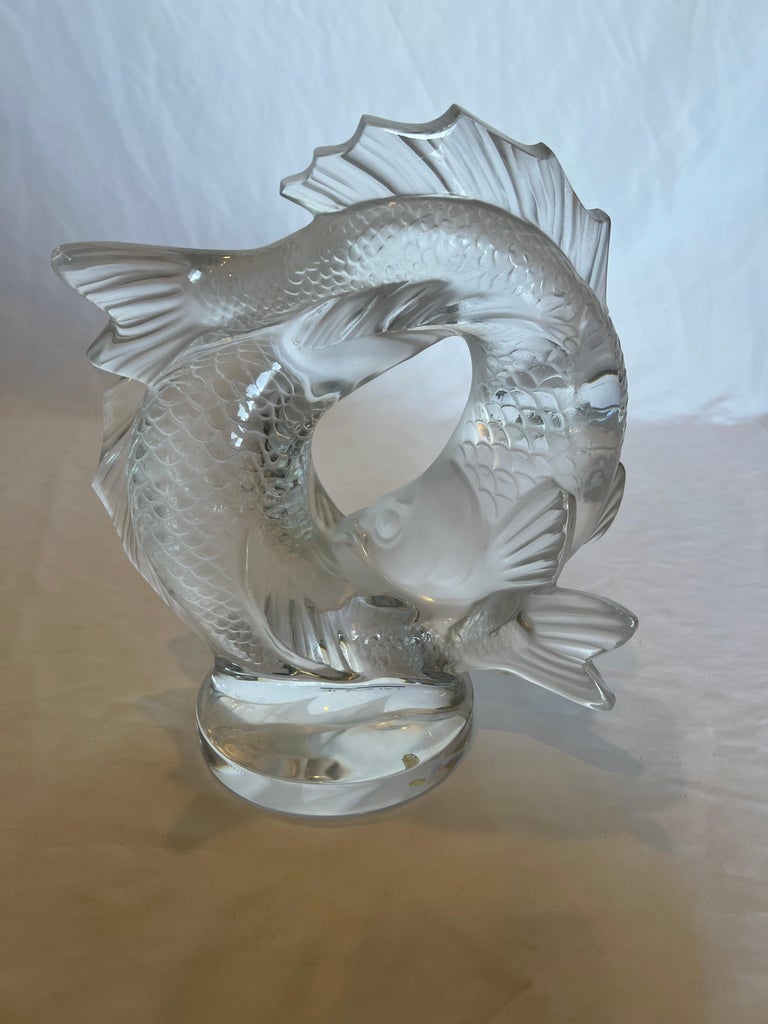 - Clear hand cut crystal featuring two fishes exiting the water, which could also represent Pisces astrological, zodiac sign
- Handmade in France
- Designed by Marc Lalique in 1953
- Comes with the original box and paperwork