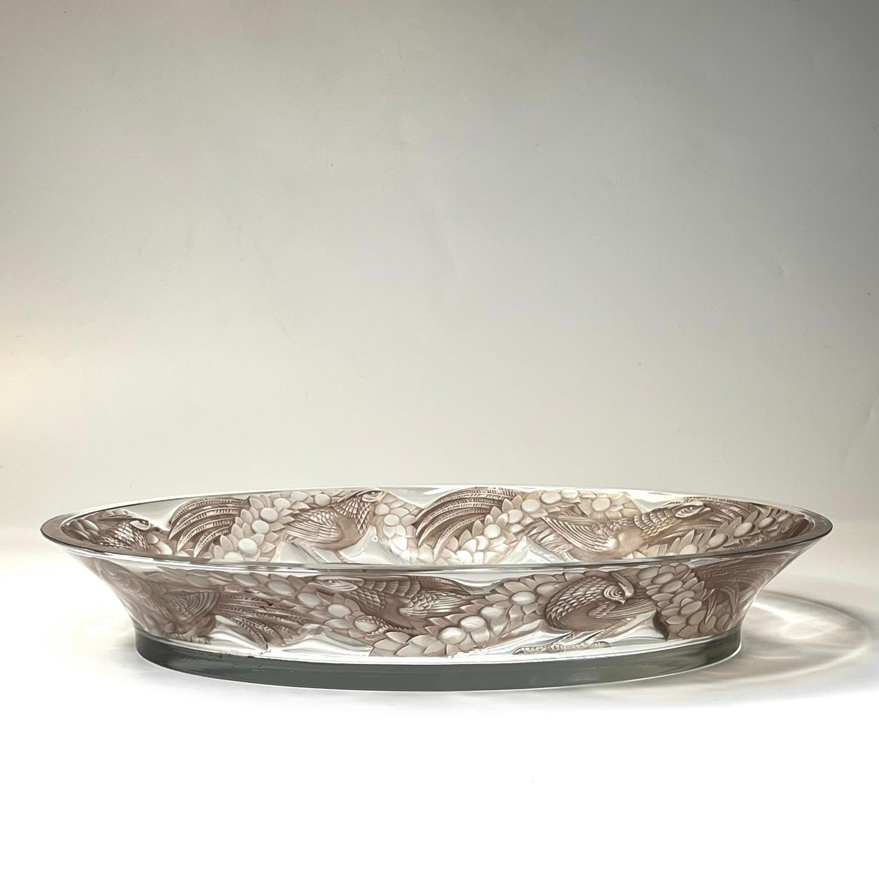 Our glass platter from Lalique, circa 1930, is known as the Faisons design, depicting pheasants in the Art Deco style in sepia colored glass over clear.