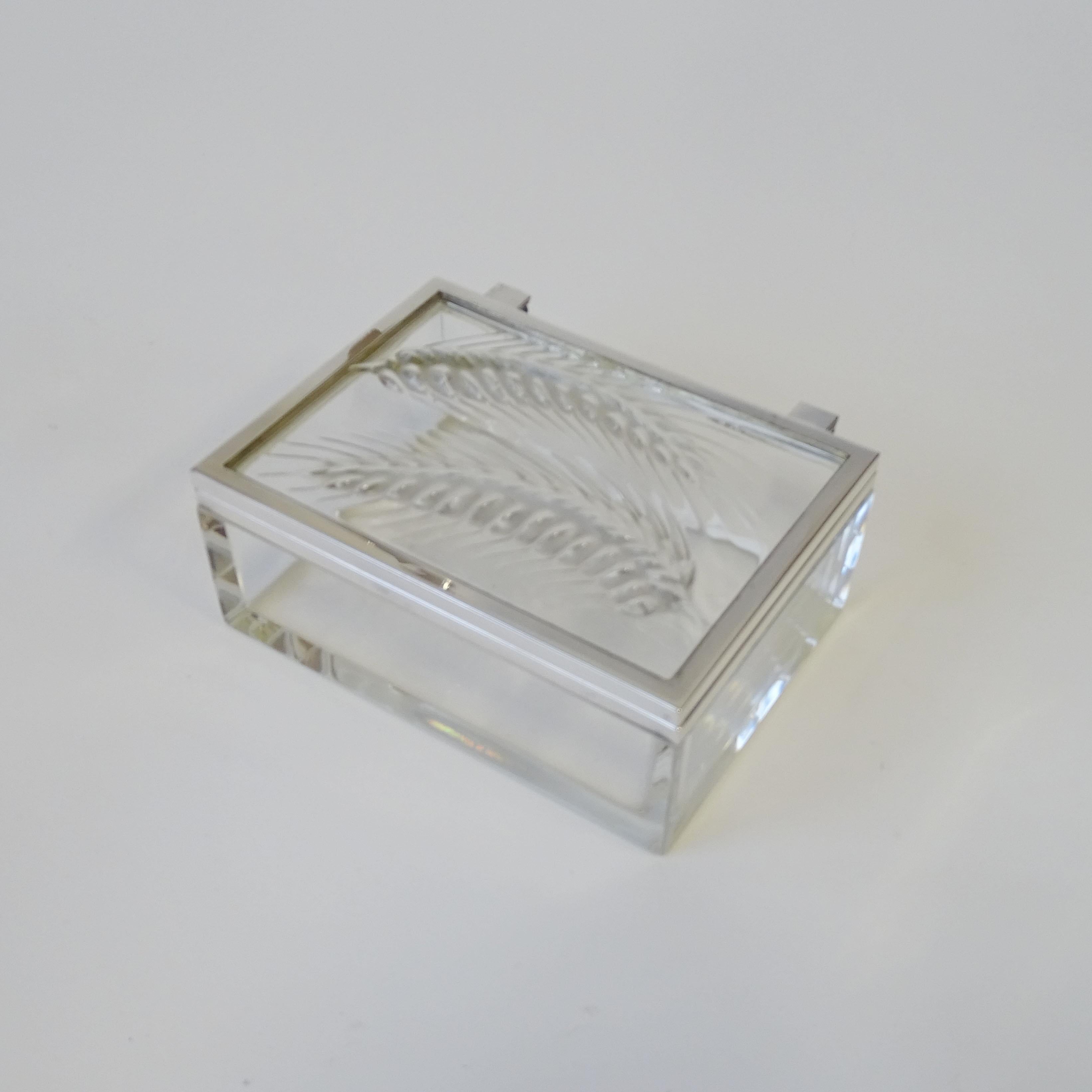 Lalique France 20th Century Epis Wheat Glass Box
Molded glass with two heads of wheat in relief, partially frosted to contrast with the transparent glass.
Signed Lalique France