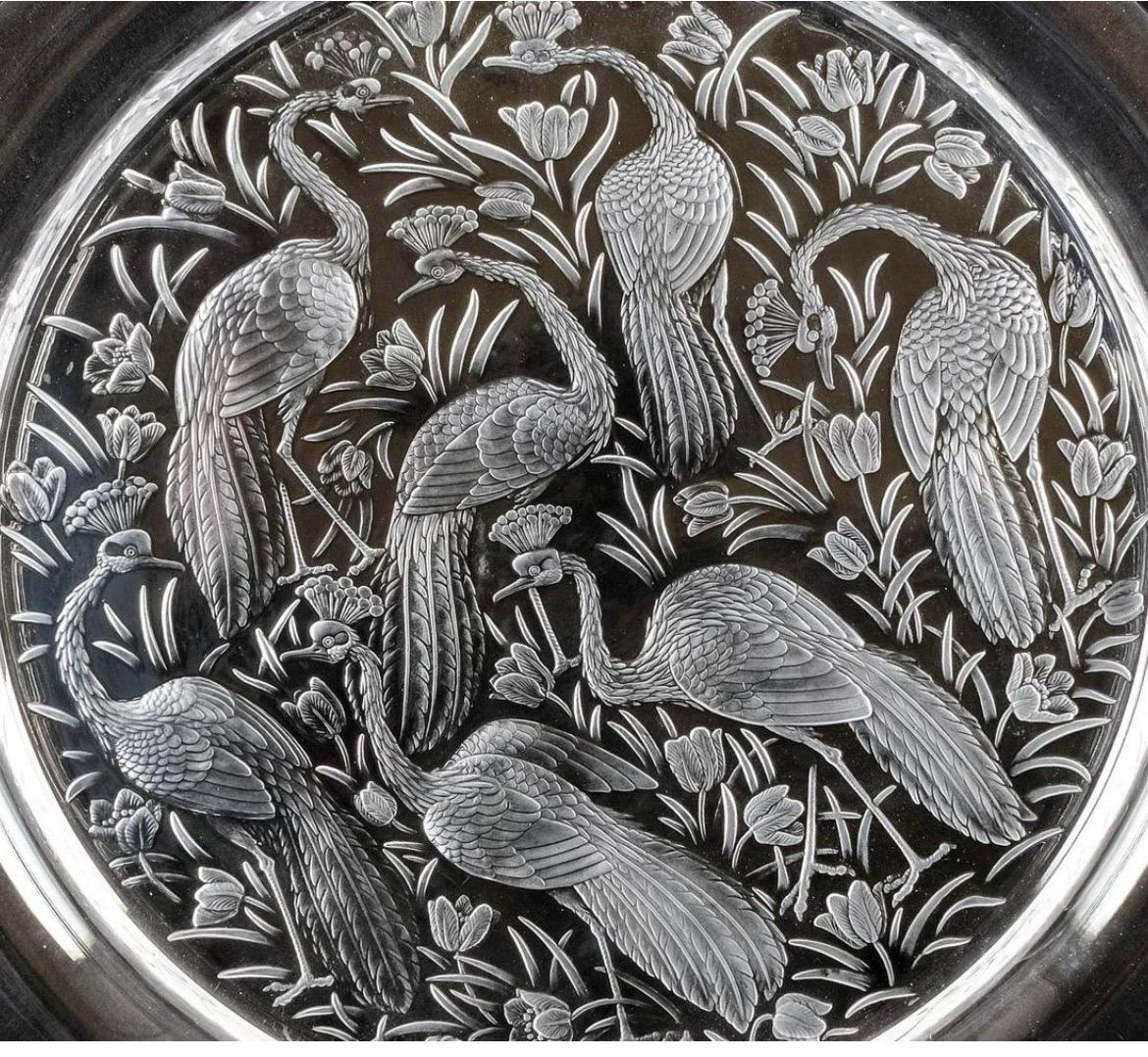 A very rare and large Lalique crystal “Nigerian” pattern crystal platter measuring 15.5”. The Nigerian pattern is heavily sculpted with 7 peacocks and various wild flowers. Marked to bottom “Lalique France”.