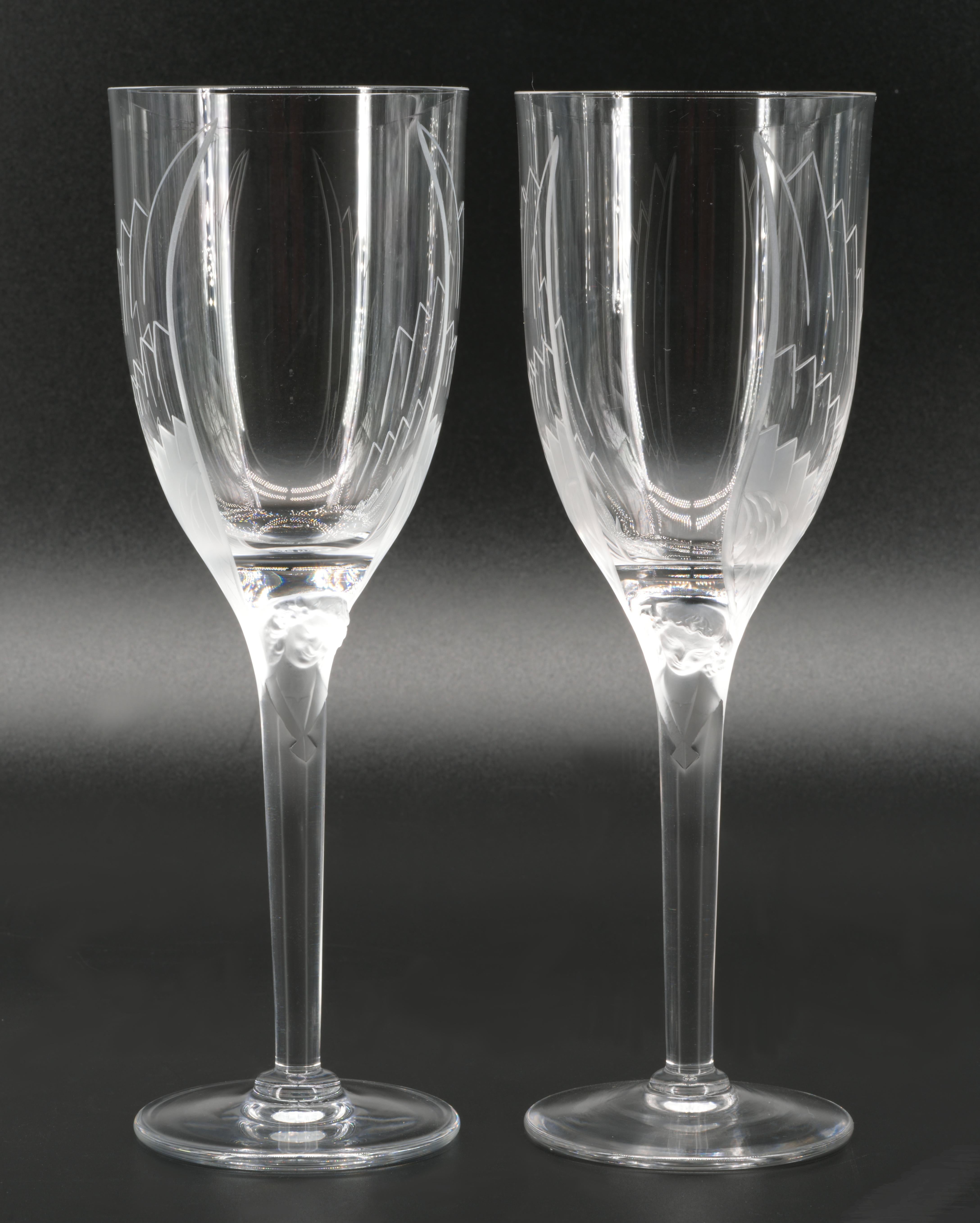Pair of champagne glasses created by Marc Lalique in 1945. This very beautiful creation shows an angel headmolded at the top of the foot spreading its large wings on the shoulder of the glass. The head and the engraved bottom of the wings are