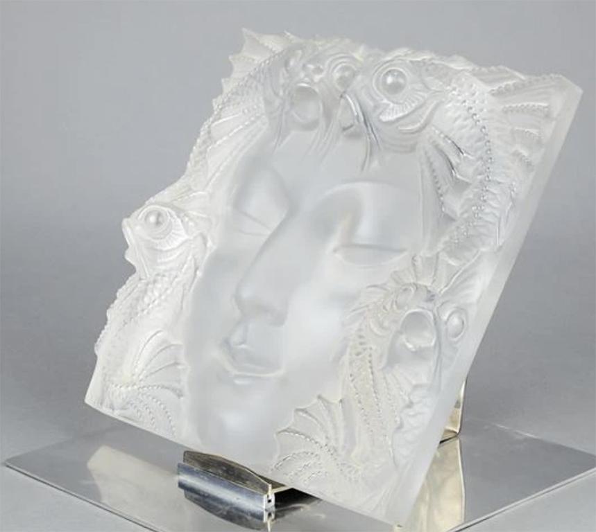 Model created in 1935 and taken up again in 1951.
Decorative motif for the «Fontaine Poissons» or «Masque femme» in white moulded - pressed glass.
Engraved signature «Lalique France».
Measures: H : 12 ½ L : 13 in.

Bibliography: Félix