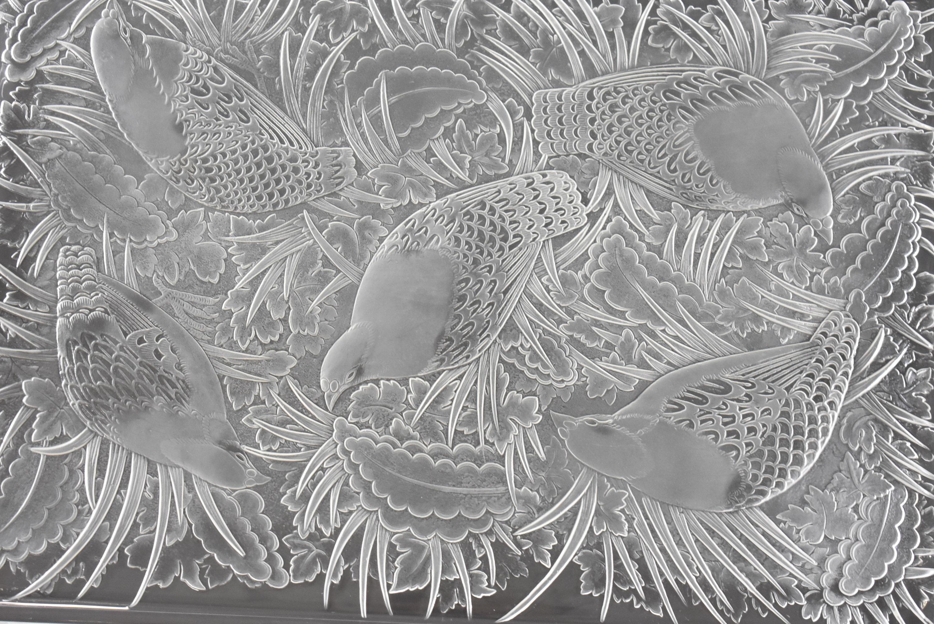 A stunning crystal platter by Lalique. This features quails in a foliage setting. This is a beautiful piece by the most renowned name in the history of French crystal, ideal to use as a functional tray or to be displayed as an objet d'art. Marked in