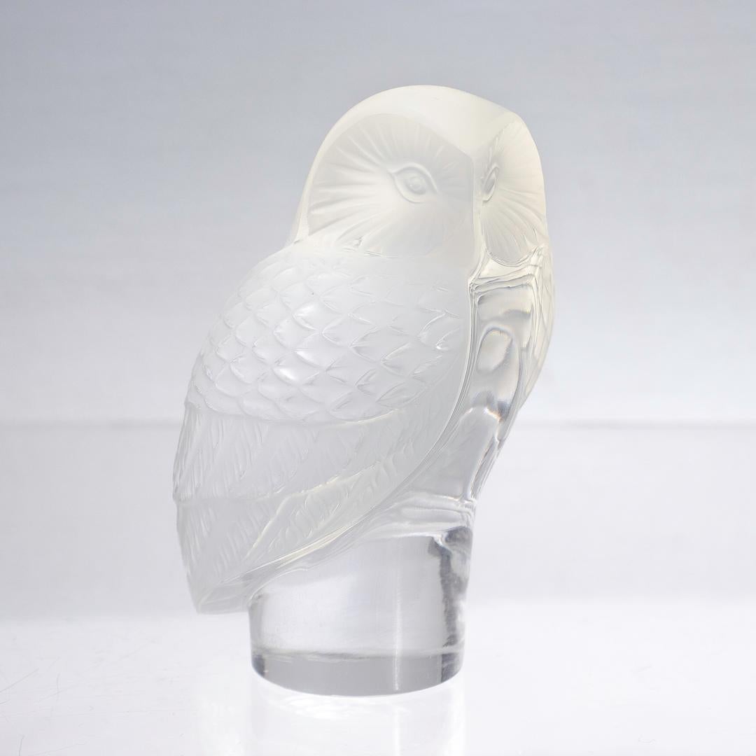 A fine figural frosted glass owl paperweight.

By Lalique.

Entitled Chouette.

With a molded owl with frosted wings perched on a clear cylindrical integral plinth.

Model no. 1193 

Reference: for a comparison see Marcilhac, R Lalique Catalogue