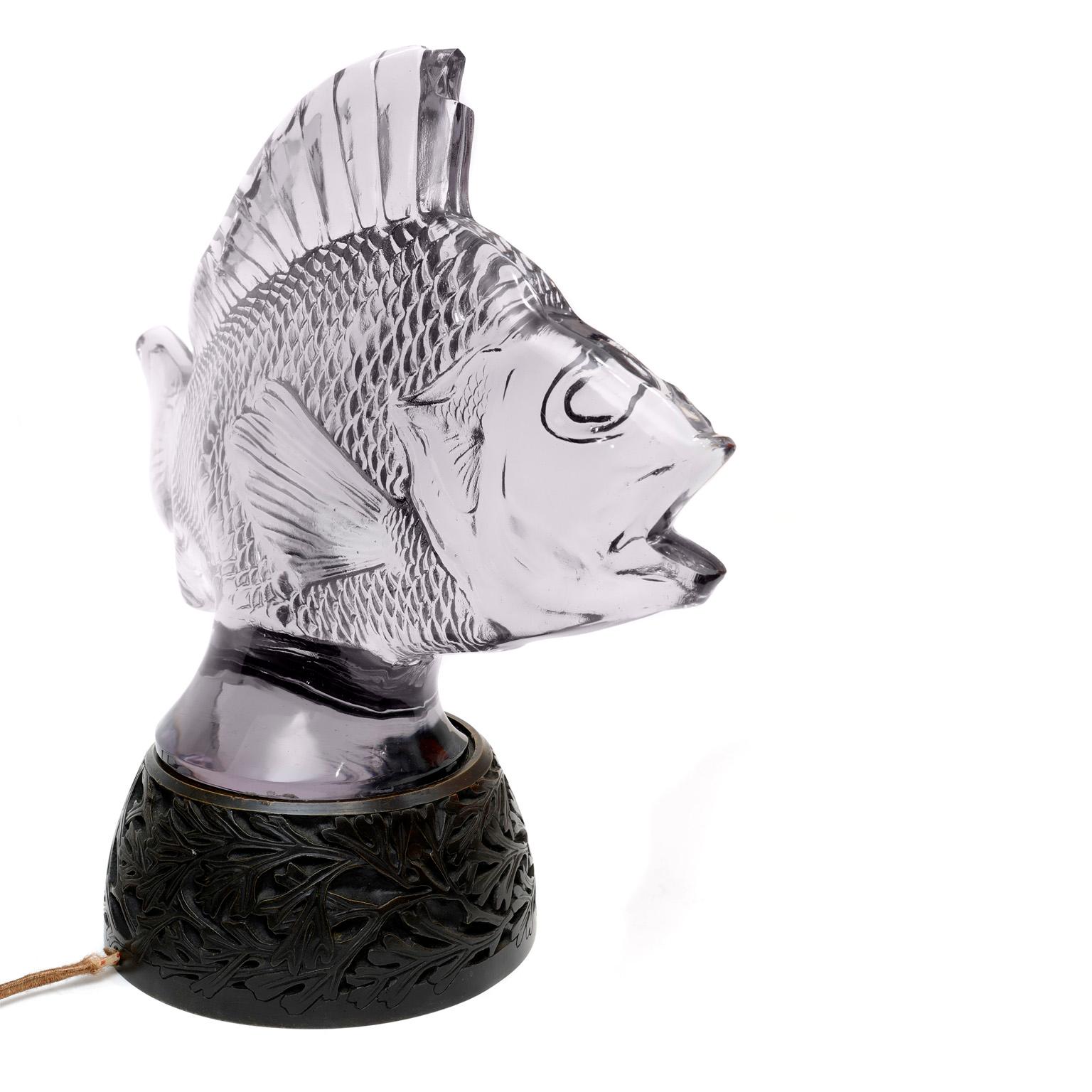 Authentic Lalique Glass Fish Sculpture Lamp, made in France.  Enhance a beachfront home,  delight a fishing enthusiast, or treat your favorite Pisces to something exquisite.  Lalique glass fish sculpture illuminates atop the simple lamp base.
PBF
