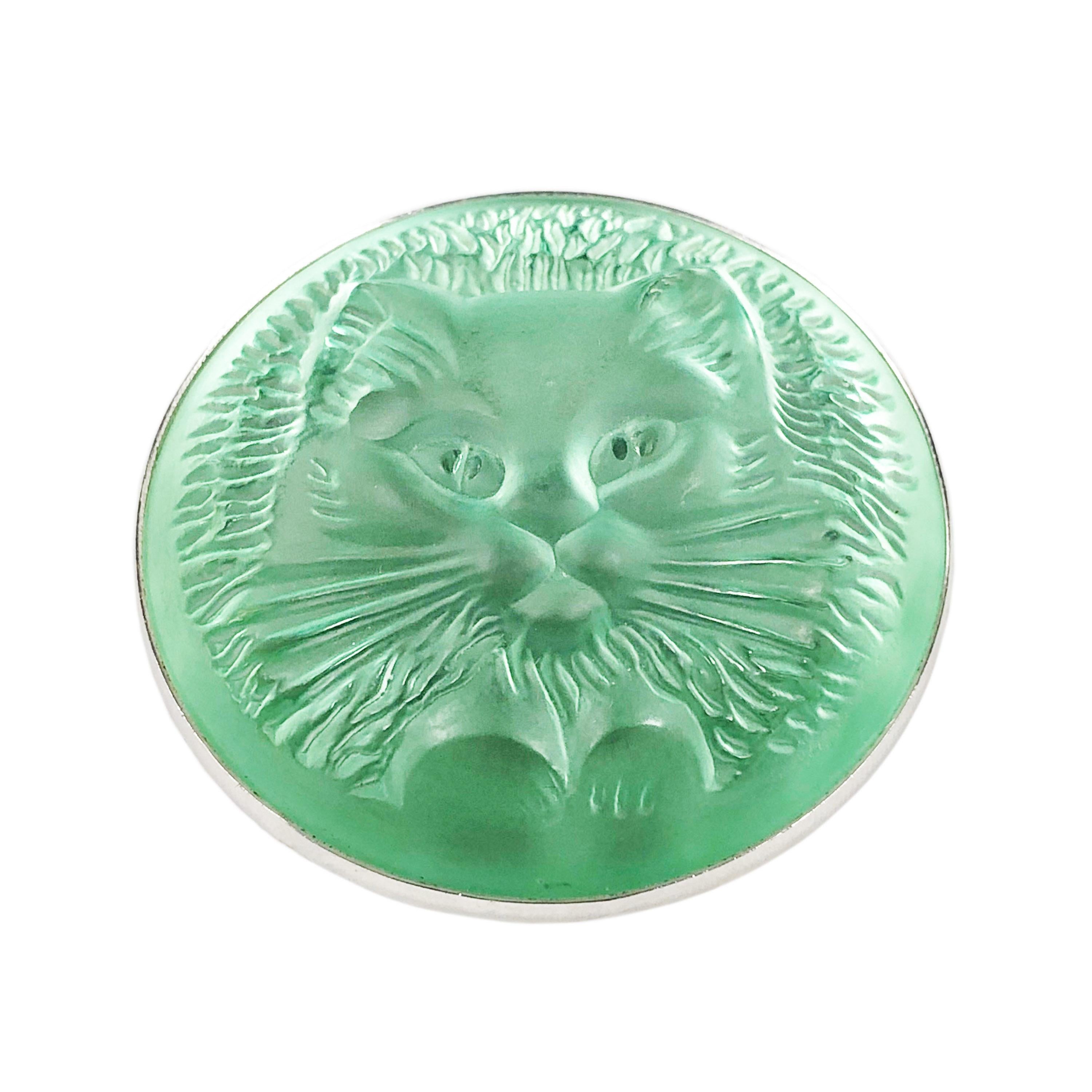 Circa 1990s Lalique Paris Pussy Cat Brooch, Green Frosted Glass Mounted in a White Metal Frame, measuring 1 3/4 inches in diameter., Comes in original Lalique Gift Box. 