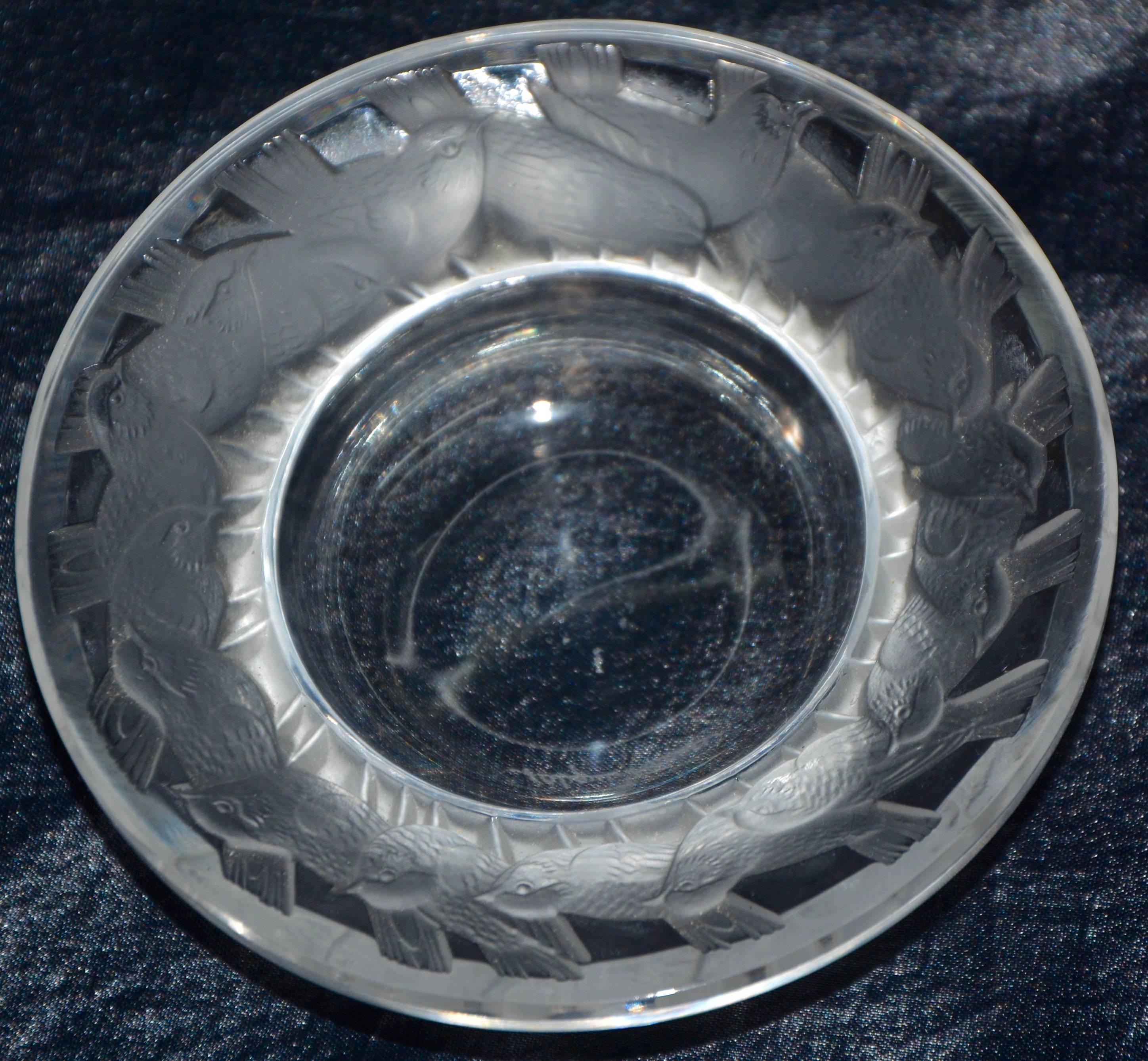 A ring of tiny sparrows are running around the rim of this Lalique of France pin dish. The dish is named Irene. The sparrows are finished in the satin finish Lalique is well known for. The piece is signed in cursive on the bottom.