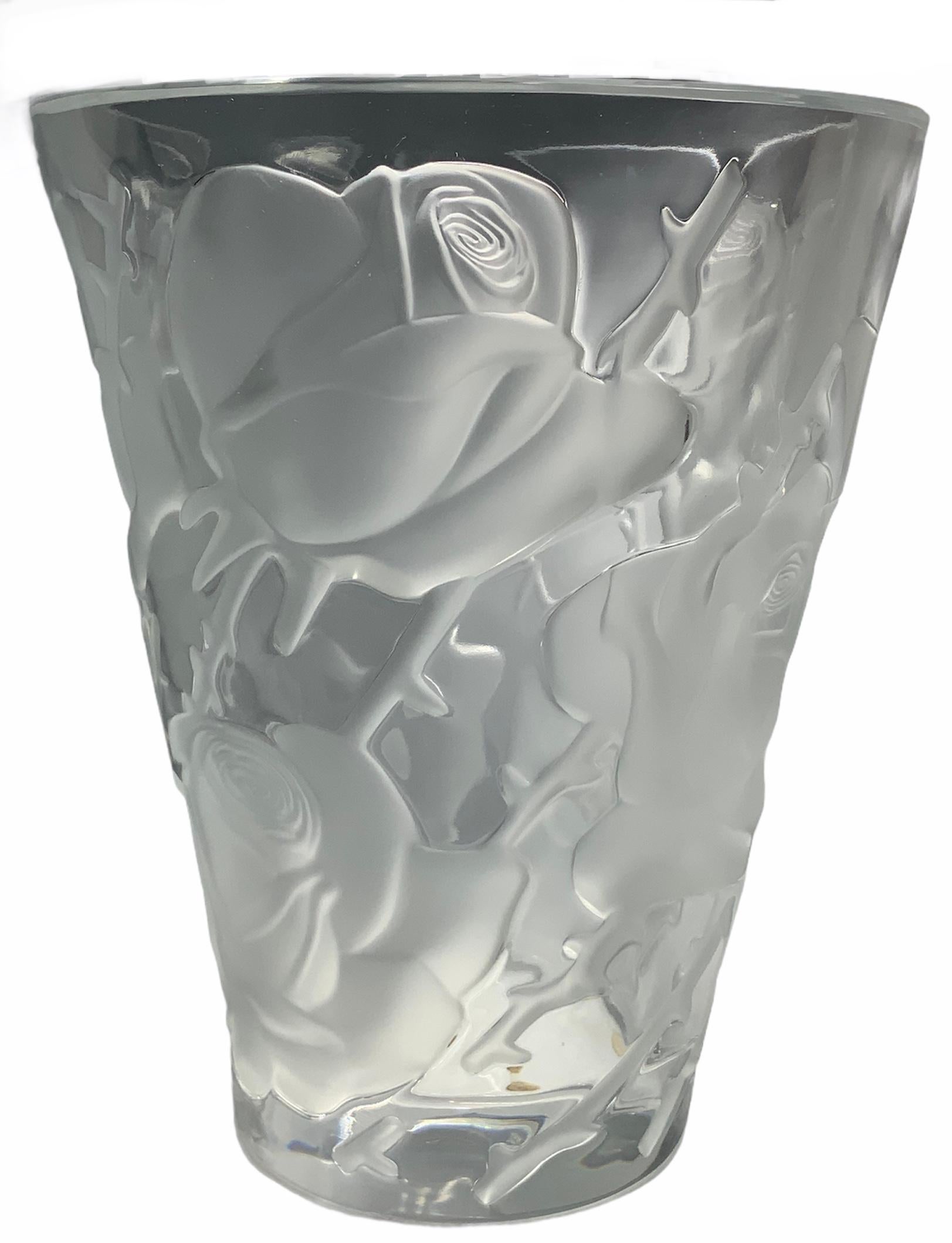 This is an upside down bell shaped, tall & wide flower crystal vase. It is adorned by engraved frosted branches of large roses all around. Under the base is marked Lalique, an encircle R & France.