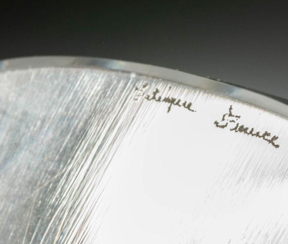 Elegant vase en verre Mortefontaine de Lalique, présentant un design givré et transparent finement sculpté. La forme gracieuse et le jeu de textures illustrent la maîtrise de Lalique dans le mélange de l'élégance inspirée de l'Art déco et de