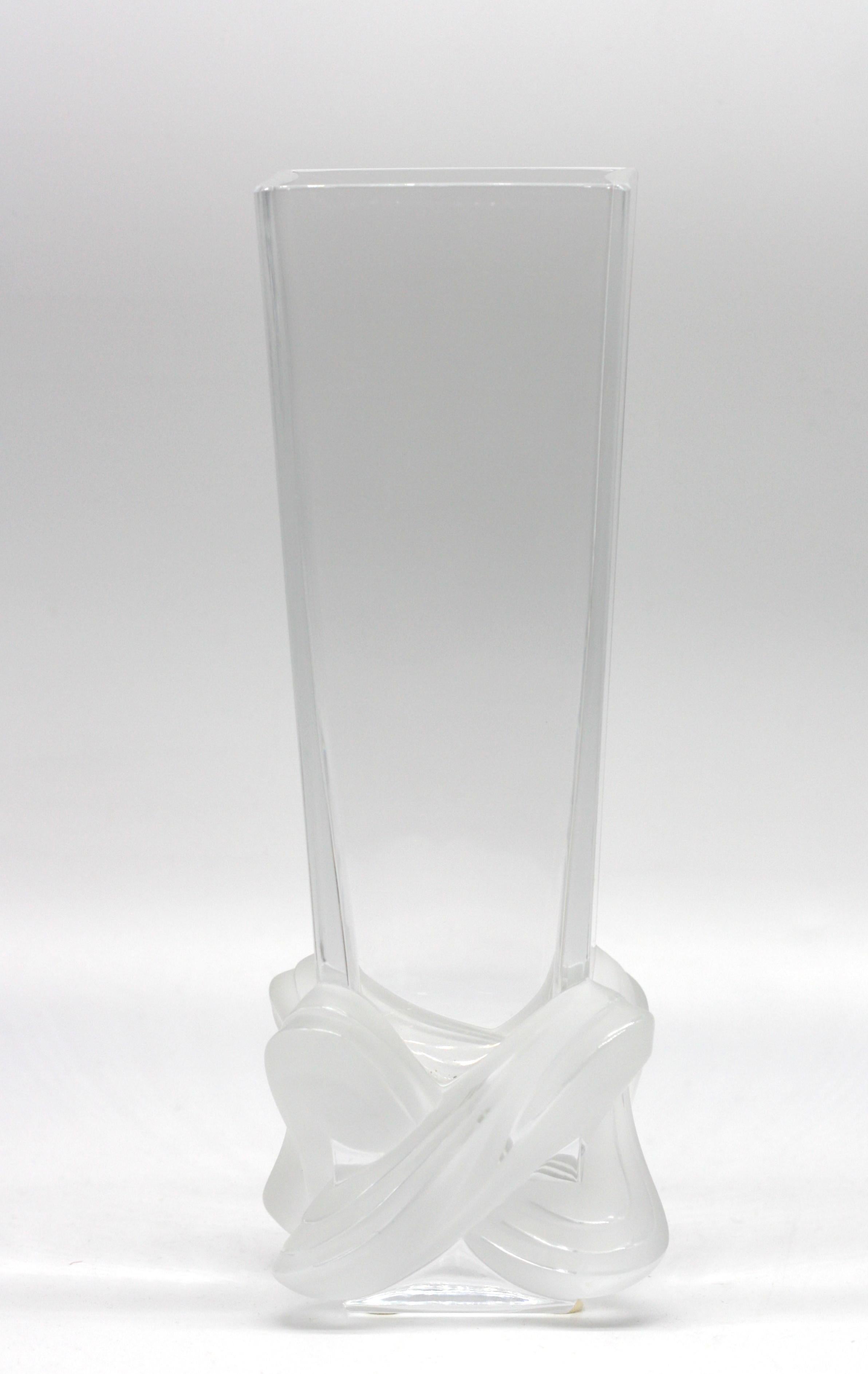 
Vase incolore en partie en cristal dépoli Lalique 
Signé M. Lalique, (Marie-Claude Lalique Dedouvre, petite-fille de René Lalique), daté 3/14/99, de forme carrée et effilée, la base givrée étant modelée comme un entrelacs de sangles, avec la boîte