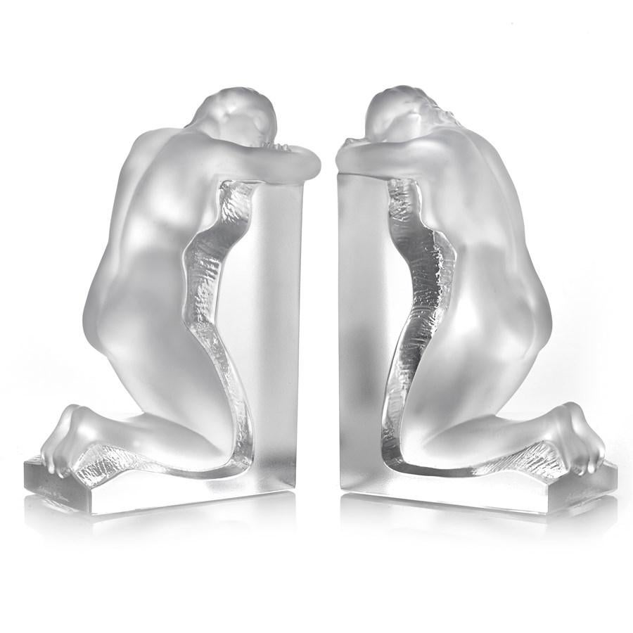 Lalique Reverie bookends.  Each handcarved crystal bookend depicts a figure resting their head, lost in a daydream. Designed by Marc Lalique.  France, circa 1948.